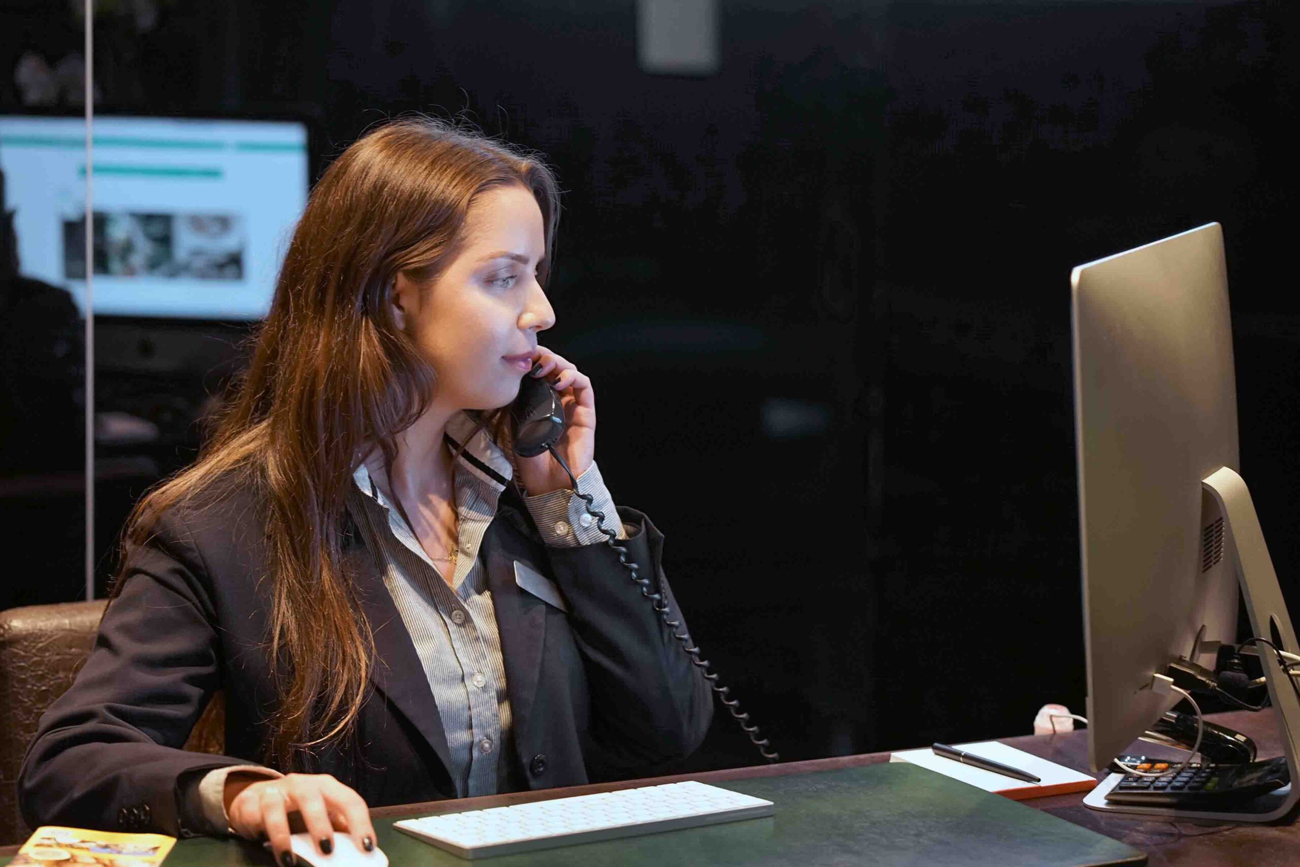 hotel receptionist taking call looking at computer