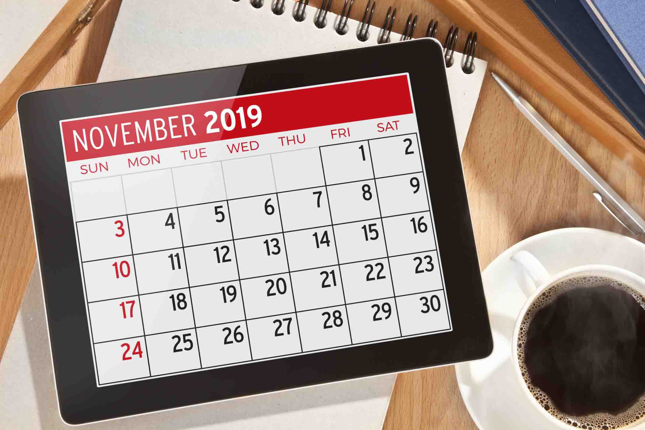 nov. 2019 calendar on tablet, coffee beside it