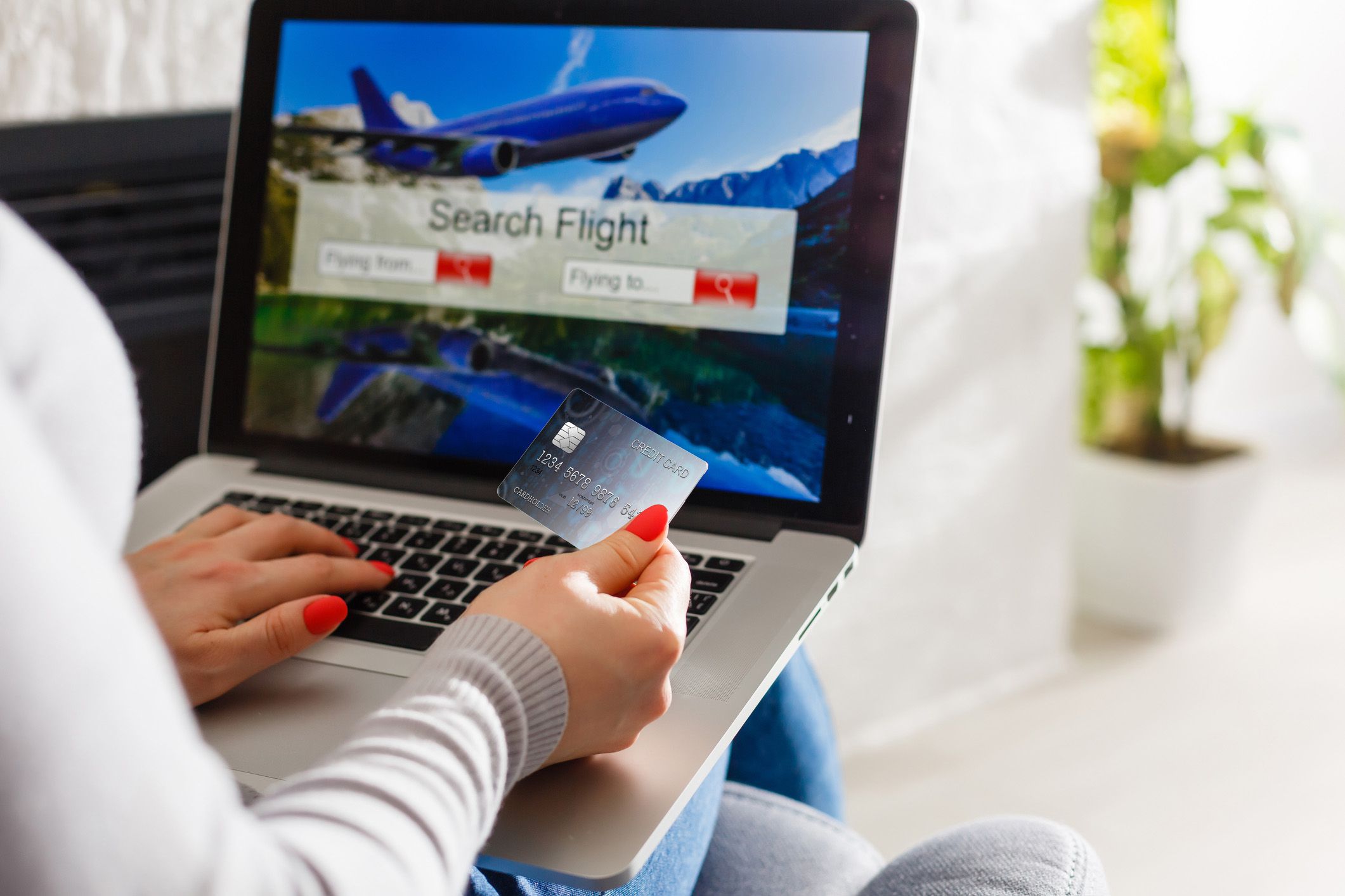 hands holding credit card and laptop with travel booking site open