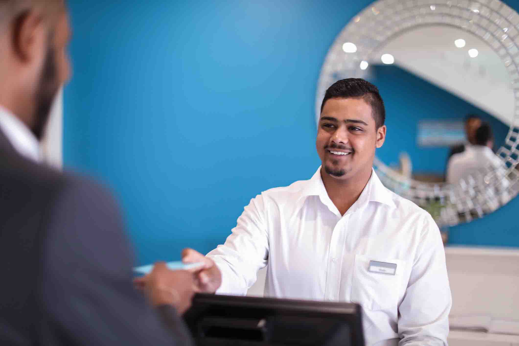 man checking into hotel receiving key from concierge