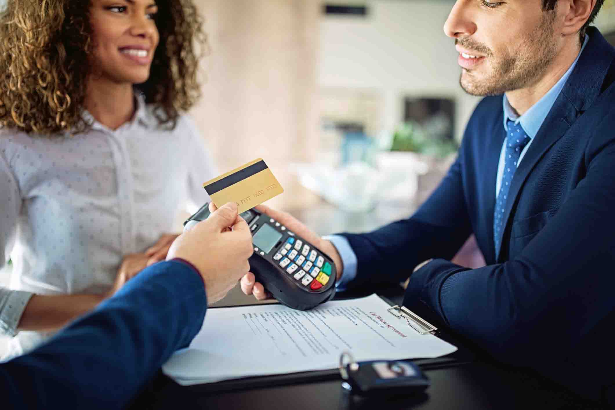 couple renting car giving card to agent