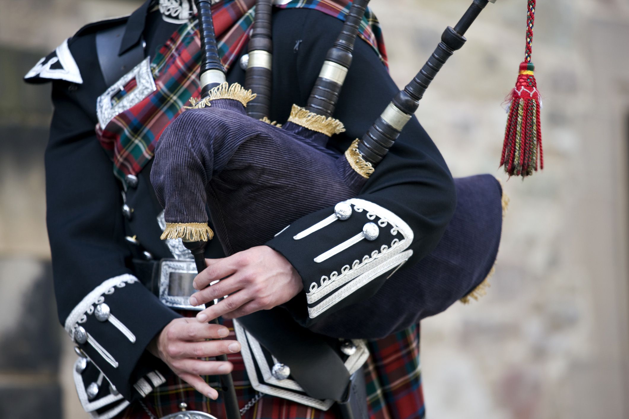 close-up mid section of a man playing the scottish bagpipes