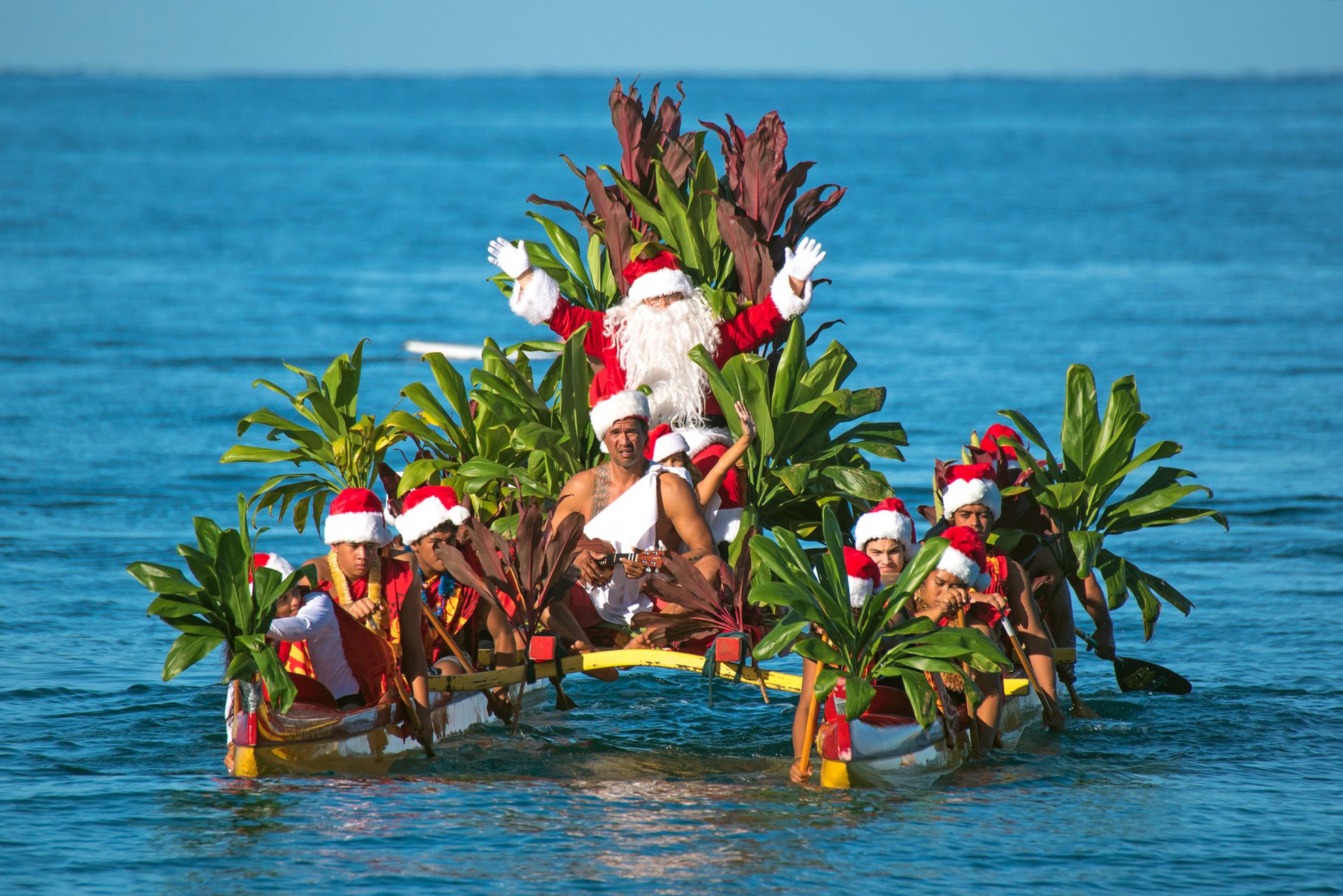 santa claus arrives by outrigger canoe at wailea beach at the grand wailea