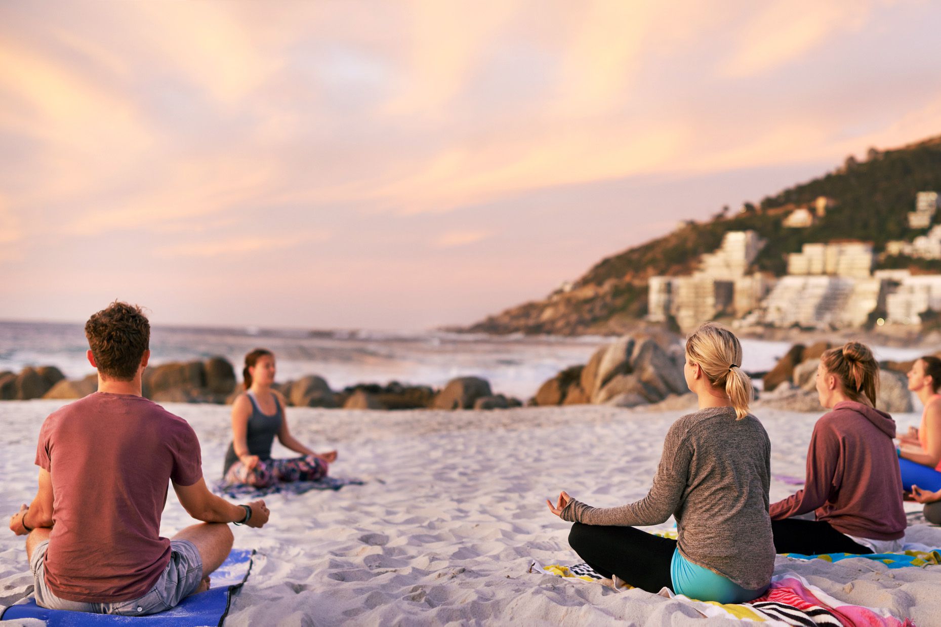 travelers doing yoga on beach