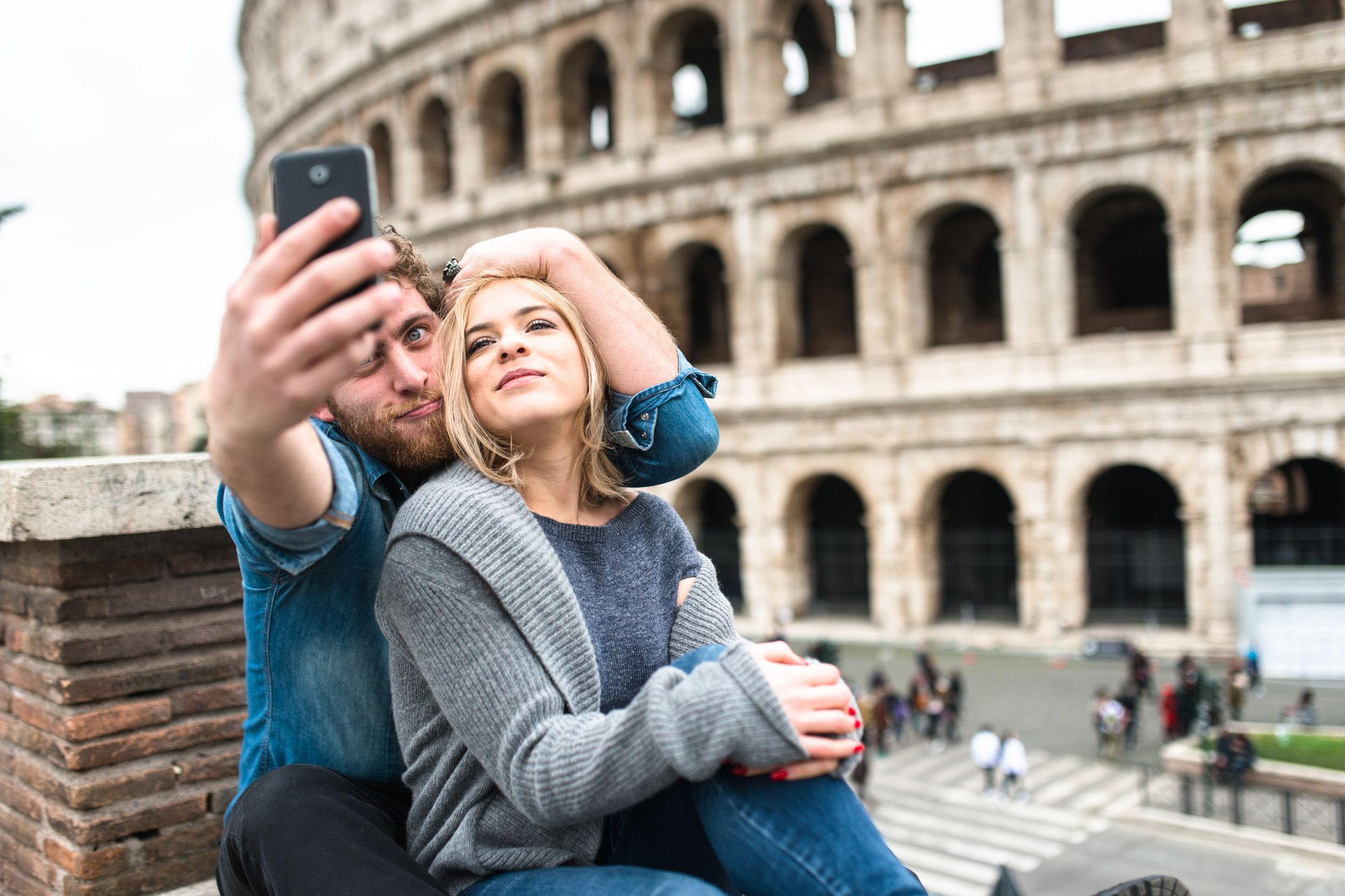 couple taking selfie in front of coliseum in rome