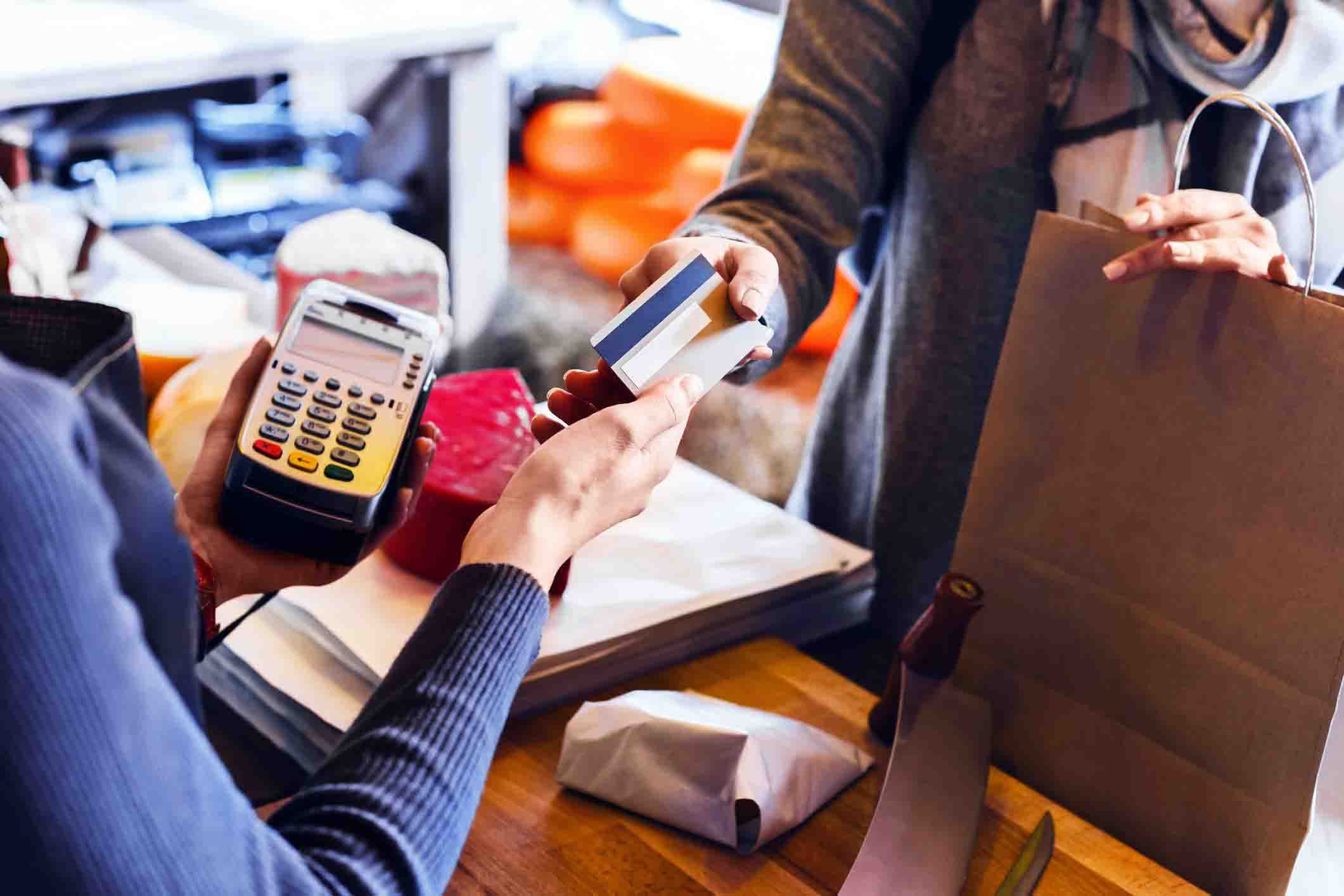 customer paying with credit card, employee holding card machine