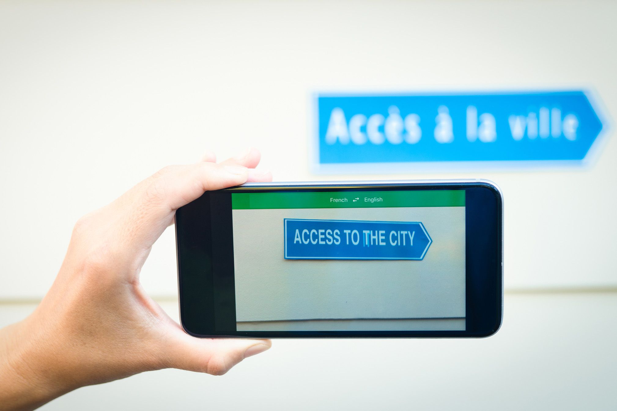 hand holding phone with language app translating sign