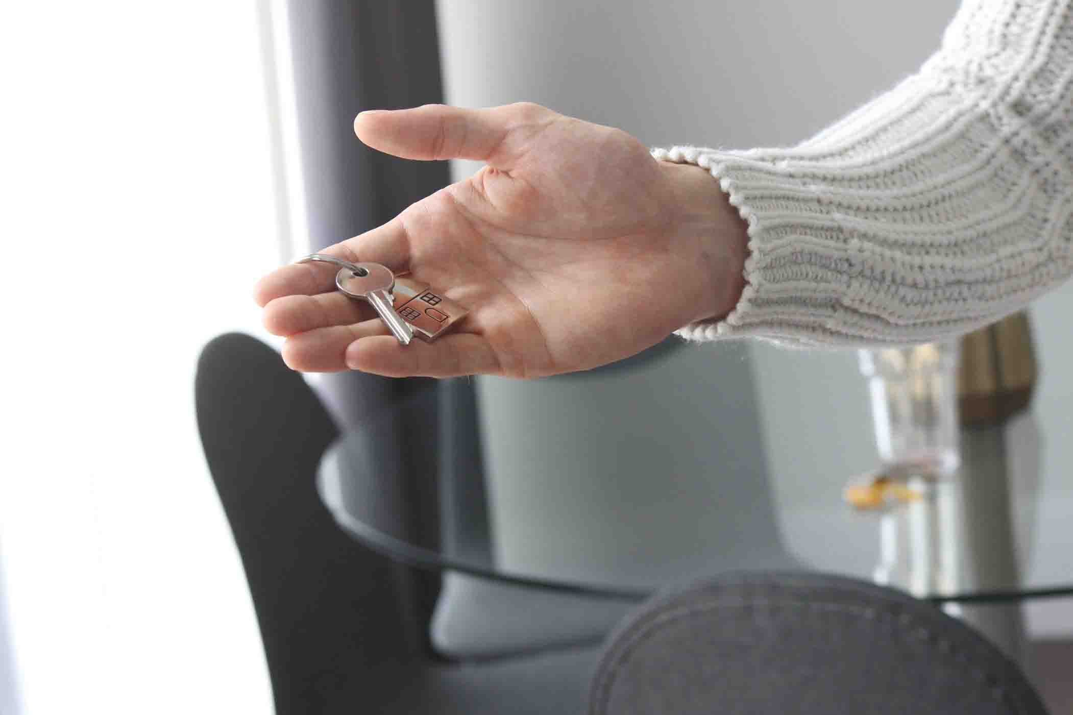 hand holding house key in house interior