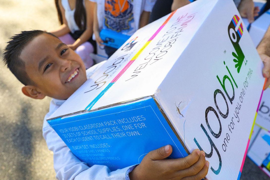 child holding box of yoobi classroom pack