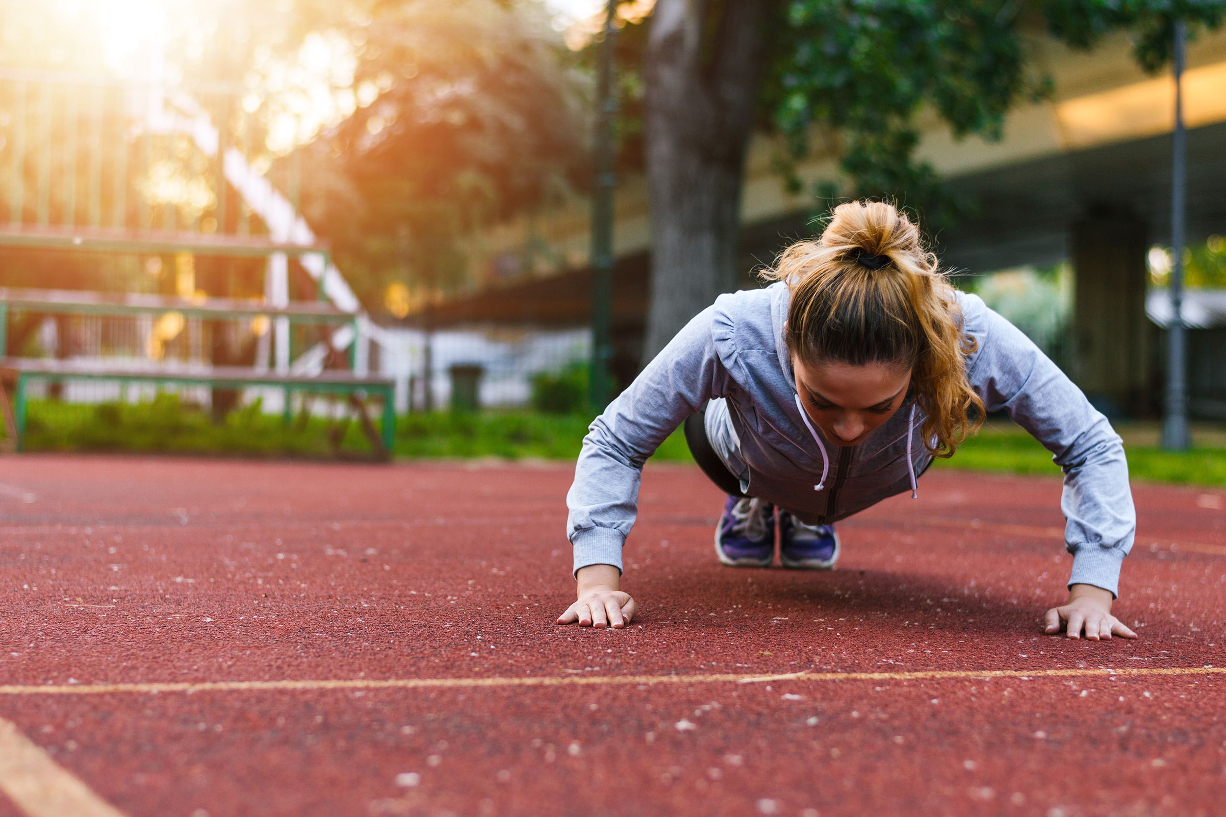woman doing pushups outside before running