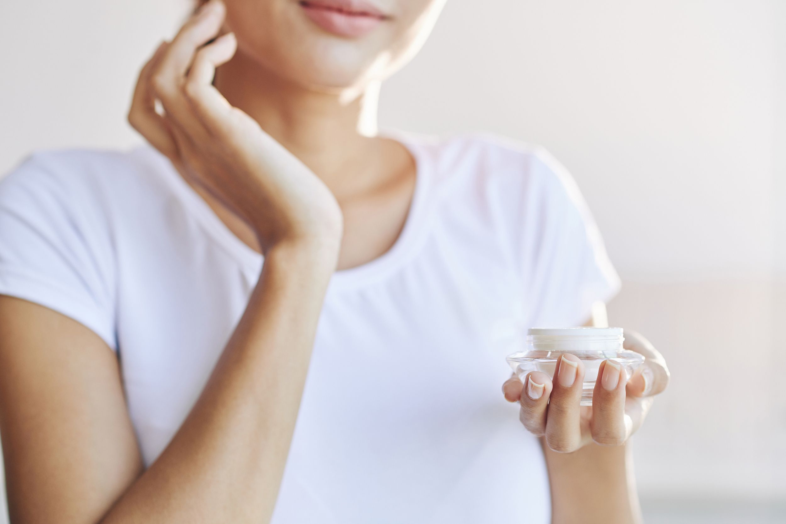 crop of woman applying face cream