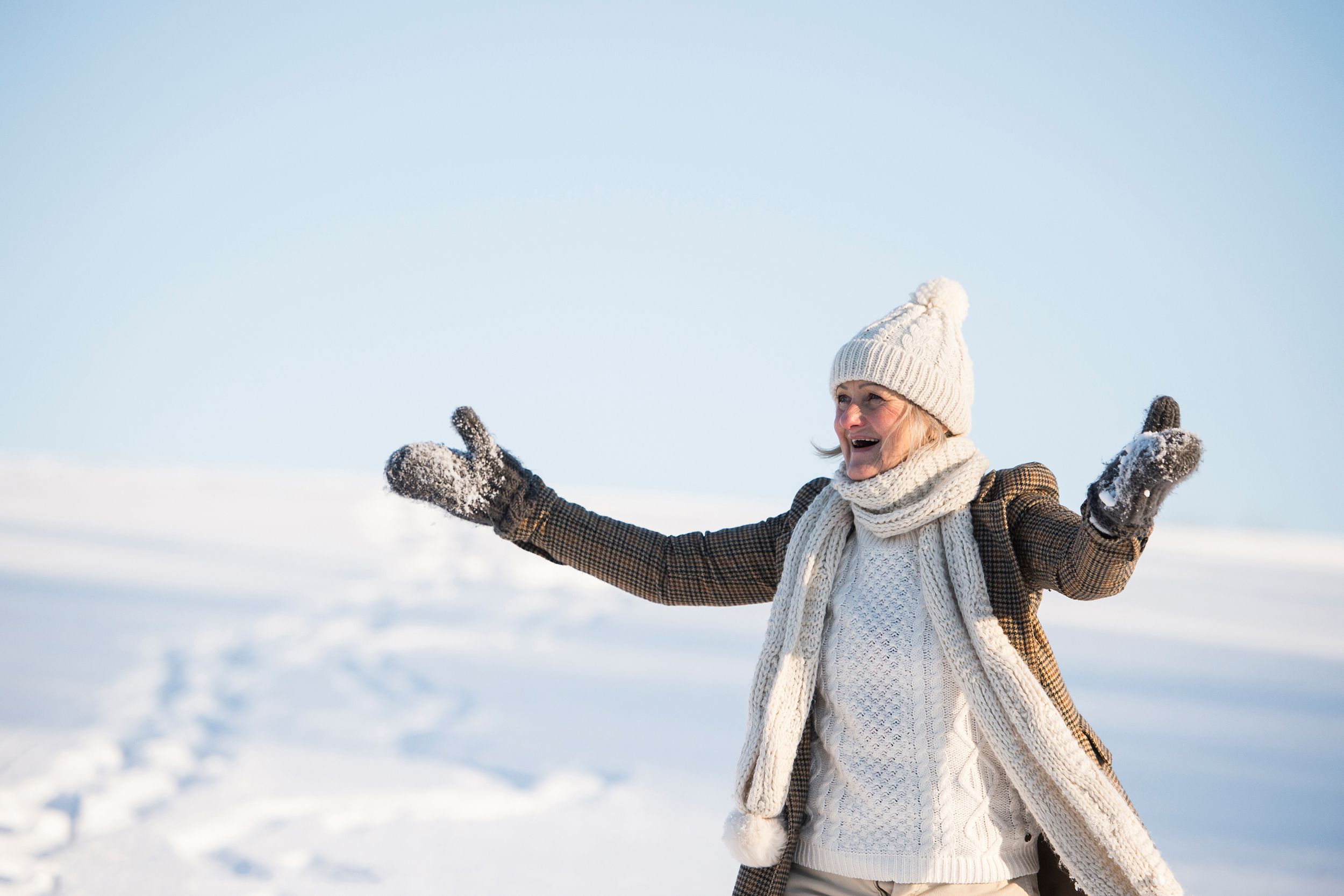 happy senior woman on a walk in sunny winter nature