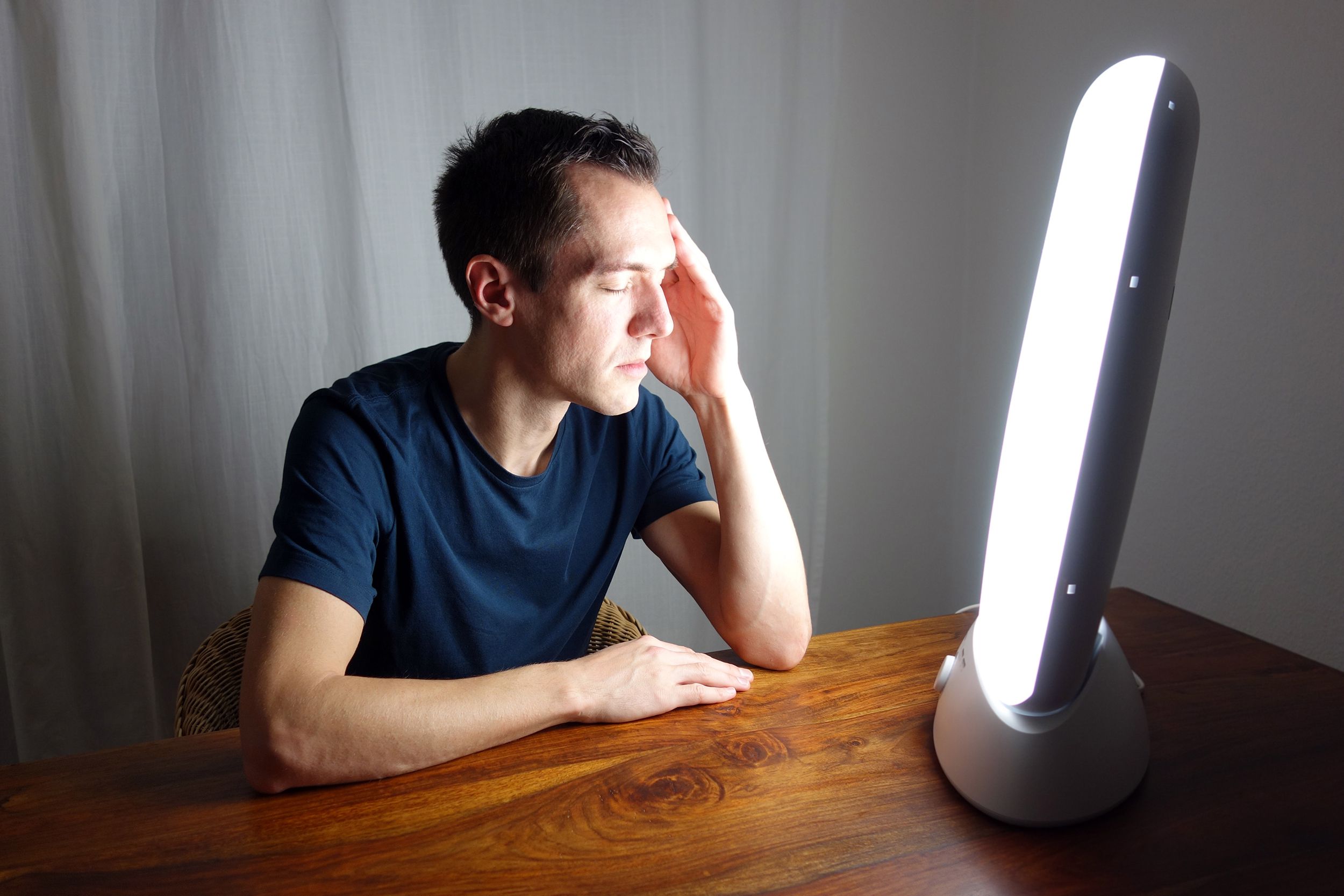man doing phototherapy at home with lightbox