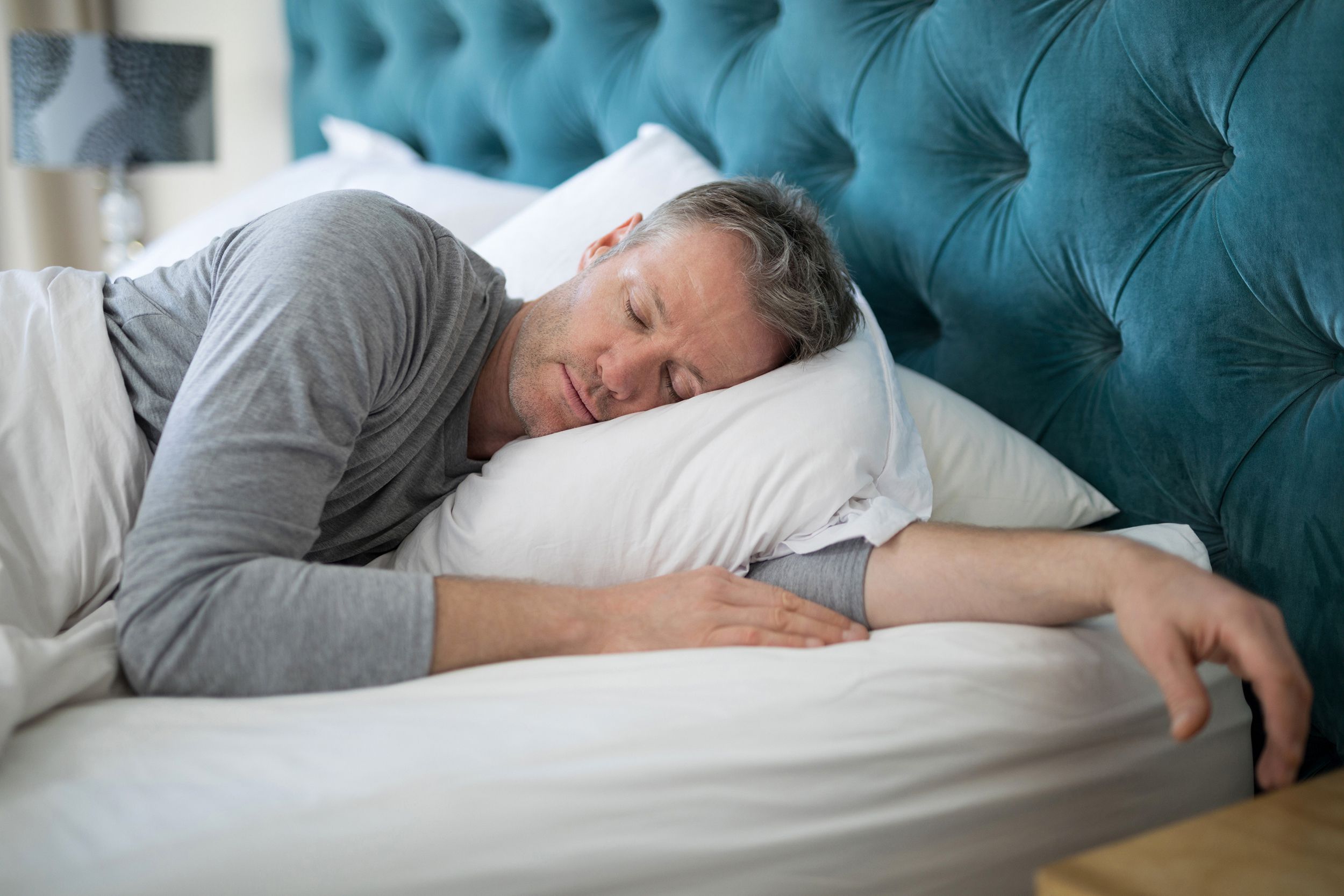 man sleeping on bed in bedroom
