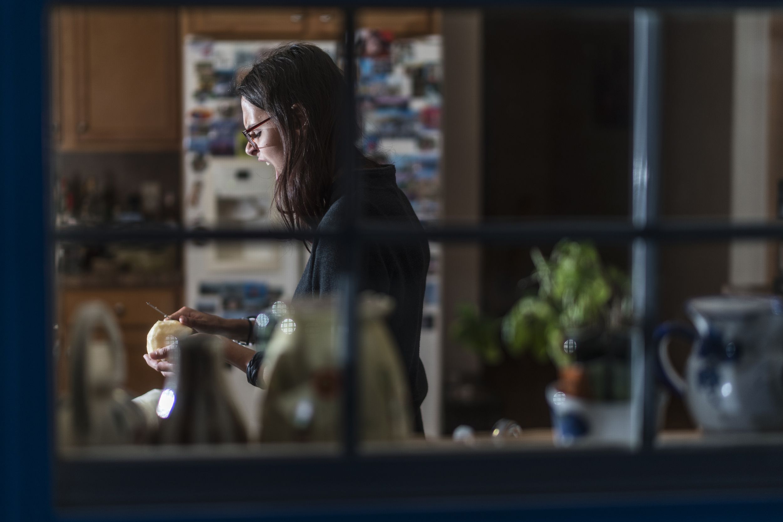angry woman preparing food at night looking through window