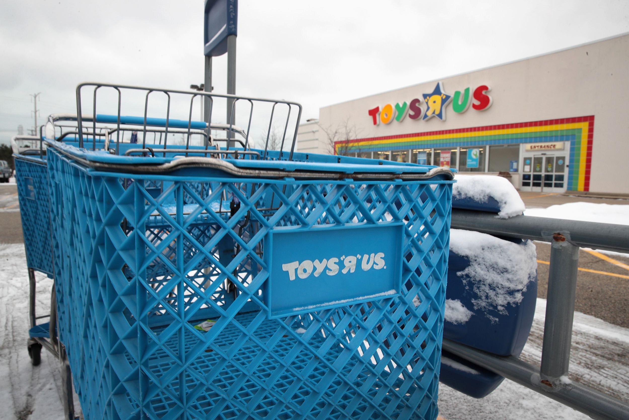 A shopping cart sits in the parking lot at a Toys 
