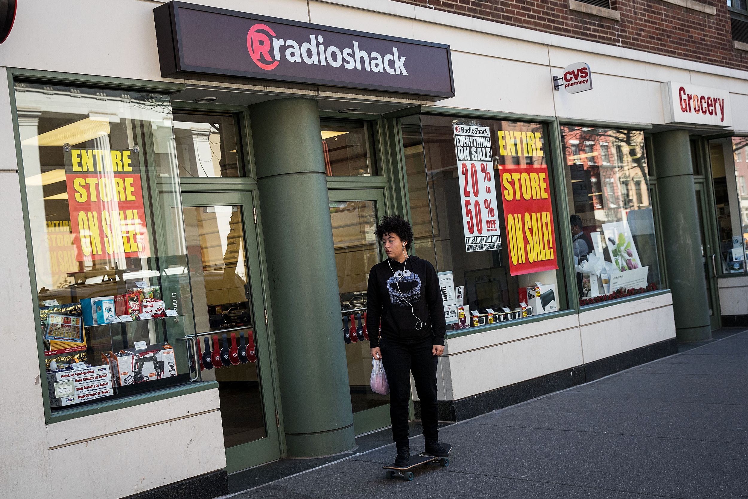 A young man rides his skateboard past a RadioShack storefront in the West Village, March 9, 2017 in New York City.