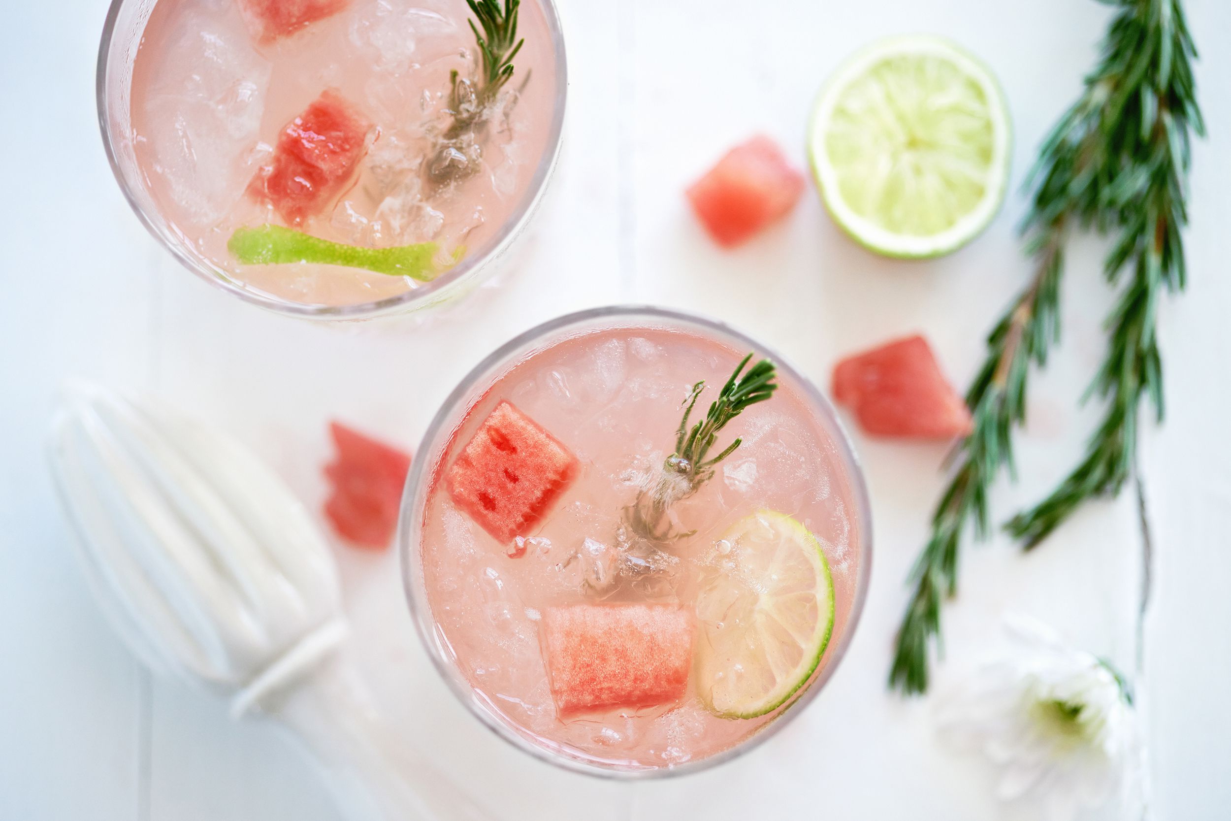 watermelon fruity cocktail mocktail drink decorated with cubes of fresh watermelon and rosemary