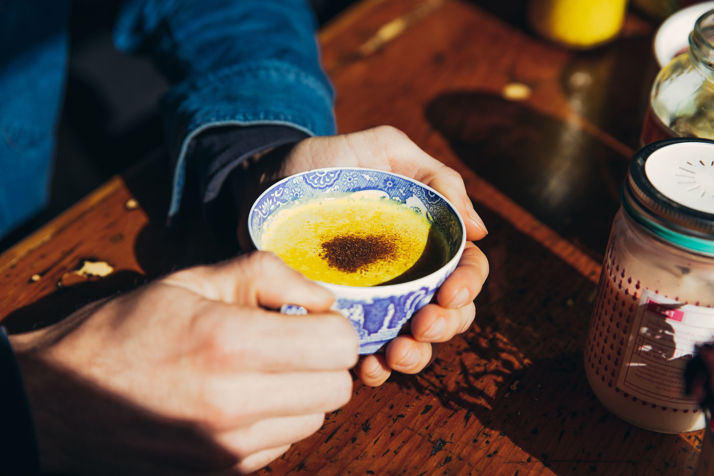 mans' hands holding golden milk