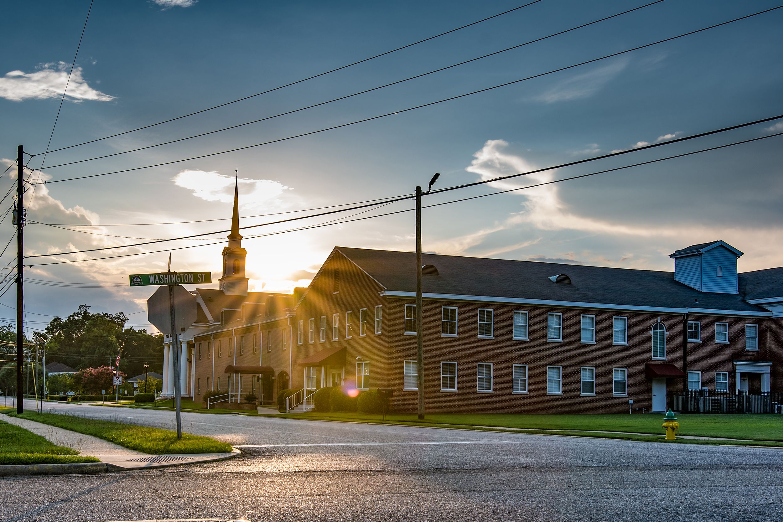 sun sets behind First Baptist Church on Washington Street in downtown Prattville, Alabama