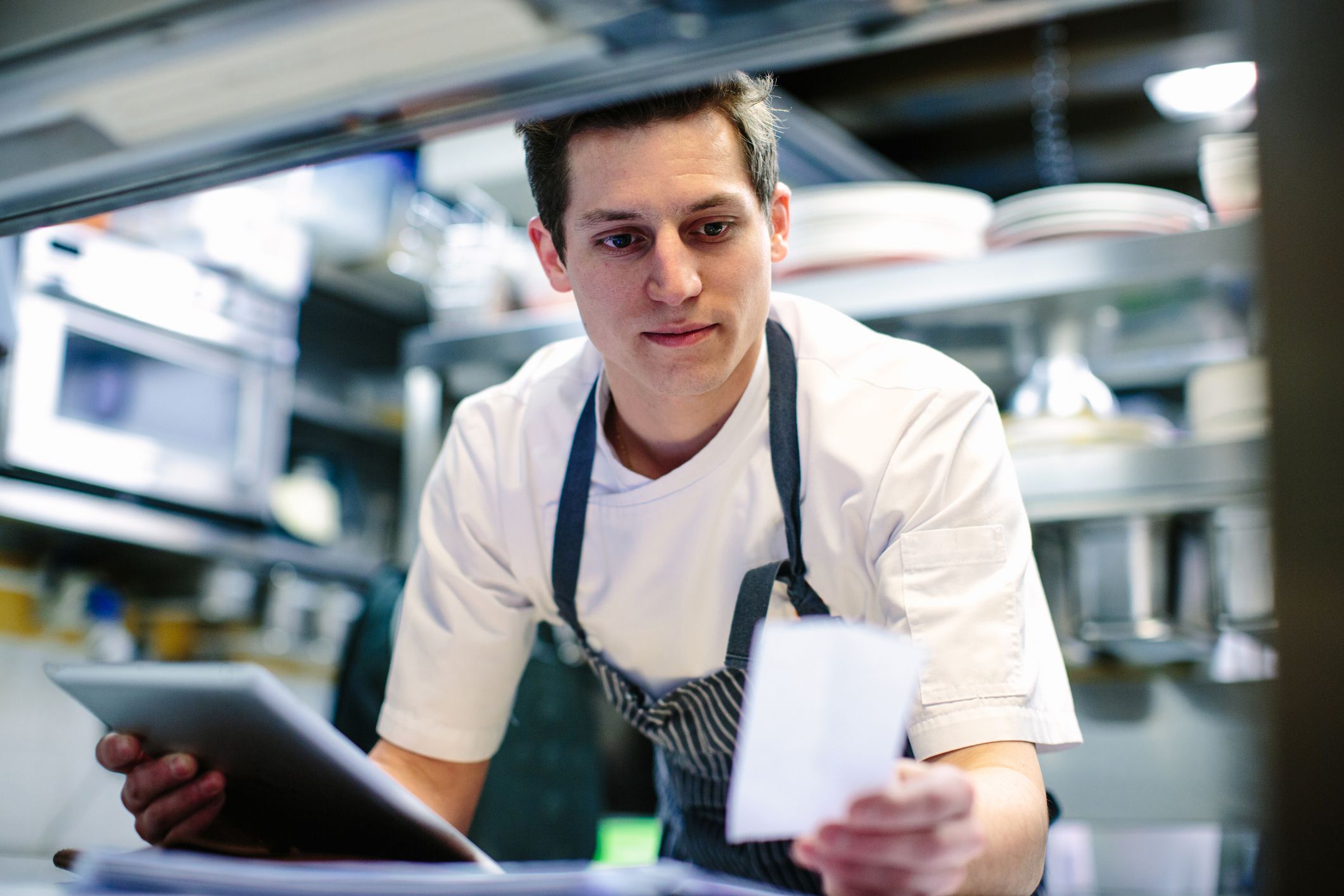 chef in kitchen consulting tablet