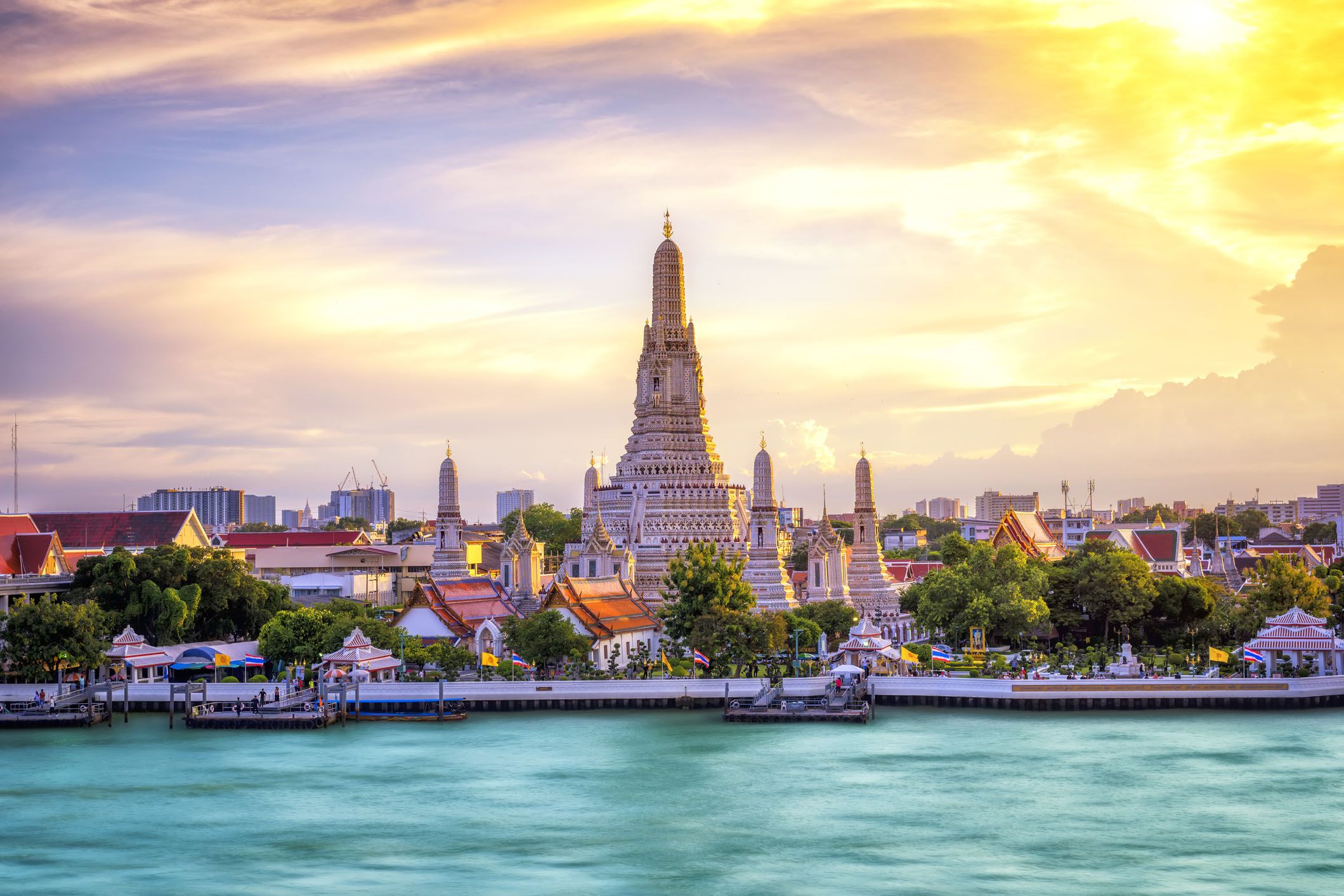 thai temple at chao phraya river side, sunset at wat arun temple in bangkok thailand