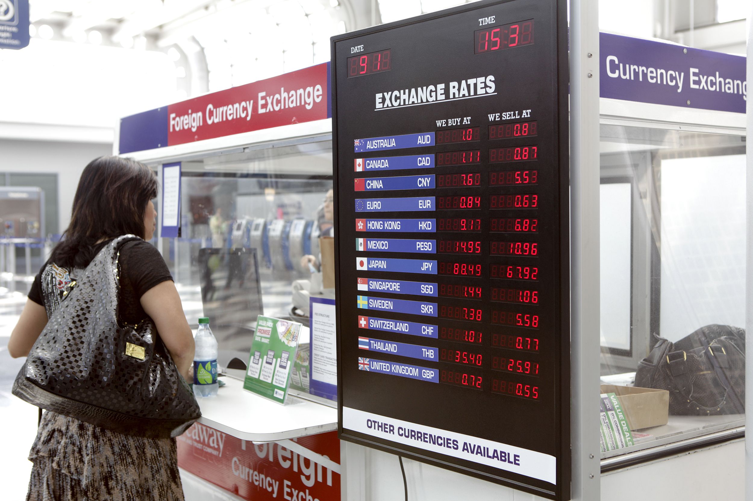woman in front of foreign currency exchange kiosk in airport