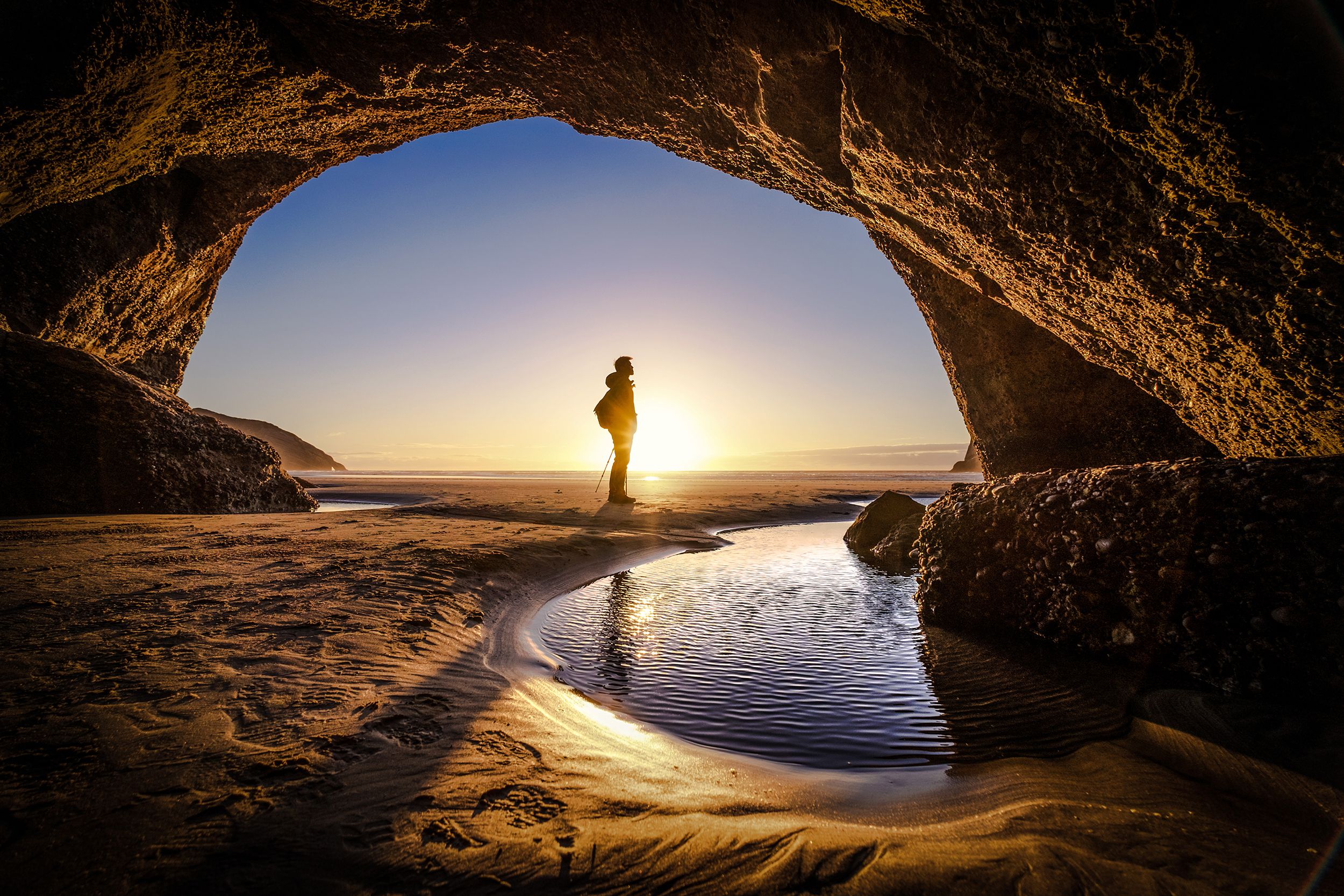 person deep thinking at the exit of a cave, New Zealand