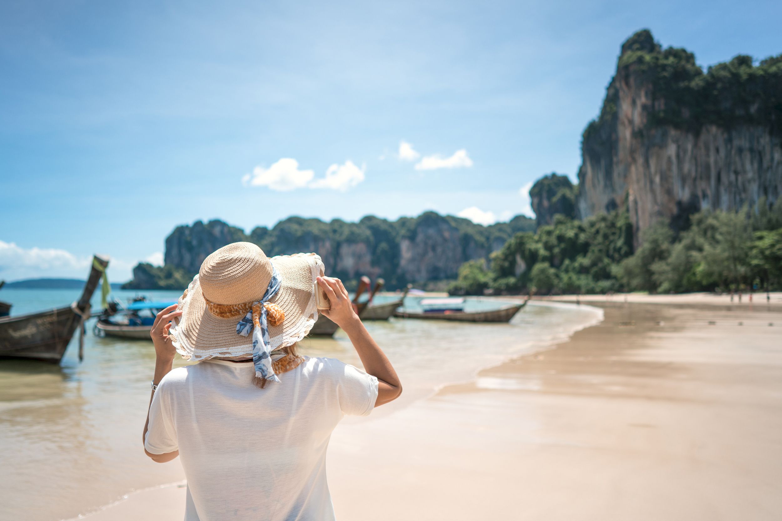 female tourist looking at the mountains while on the beach