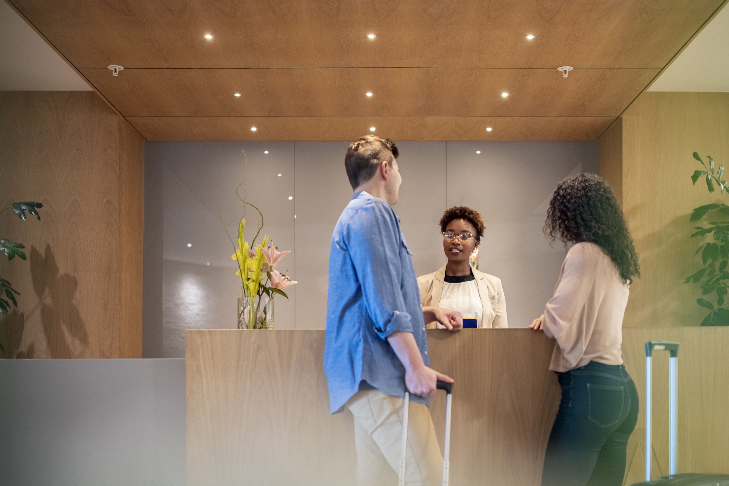 couple talking to receptionist at hotel lobby