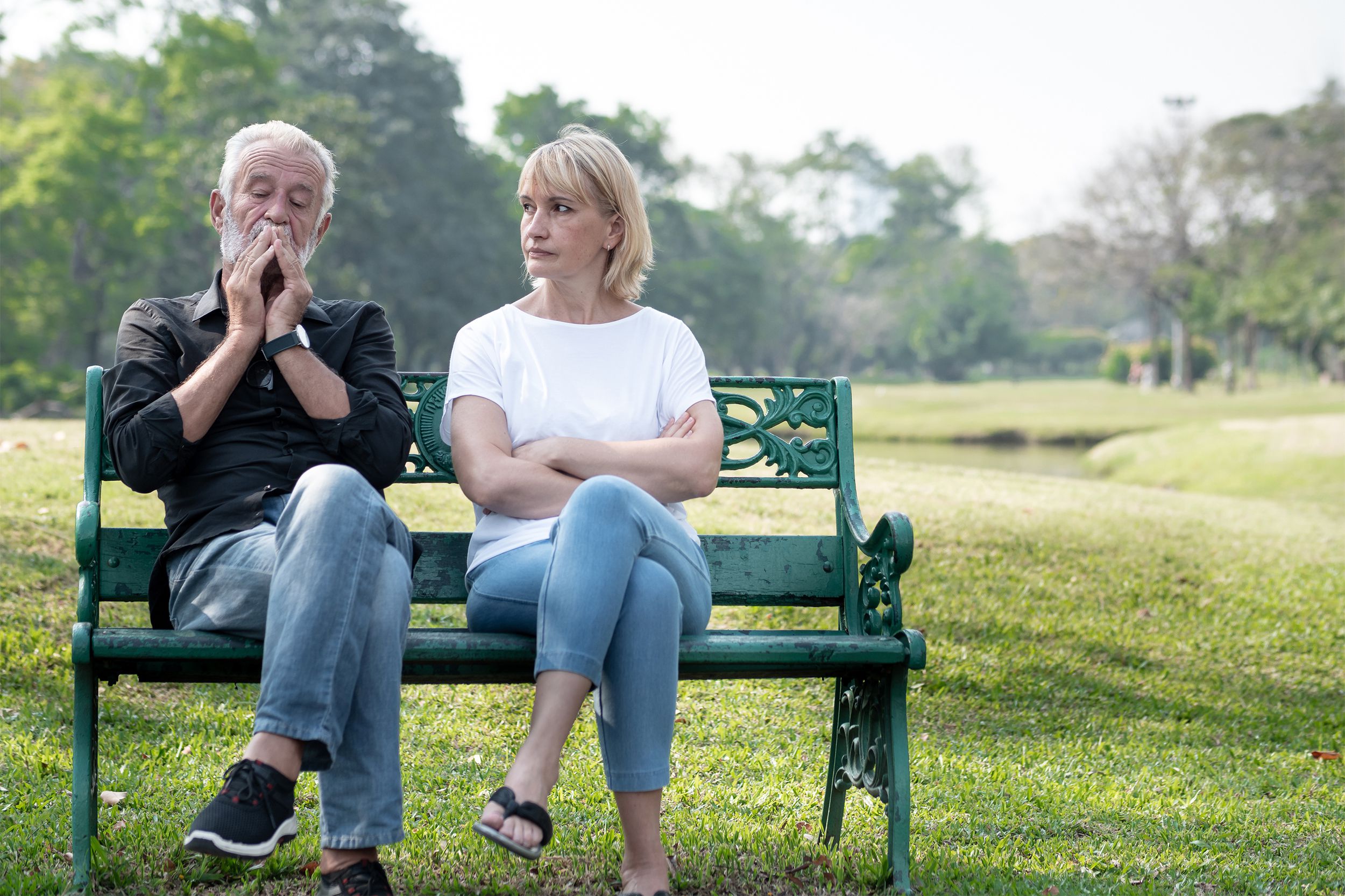 Senior couple not speaking on a park bench