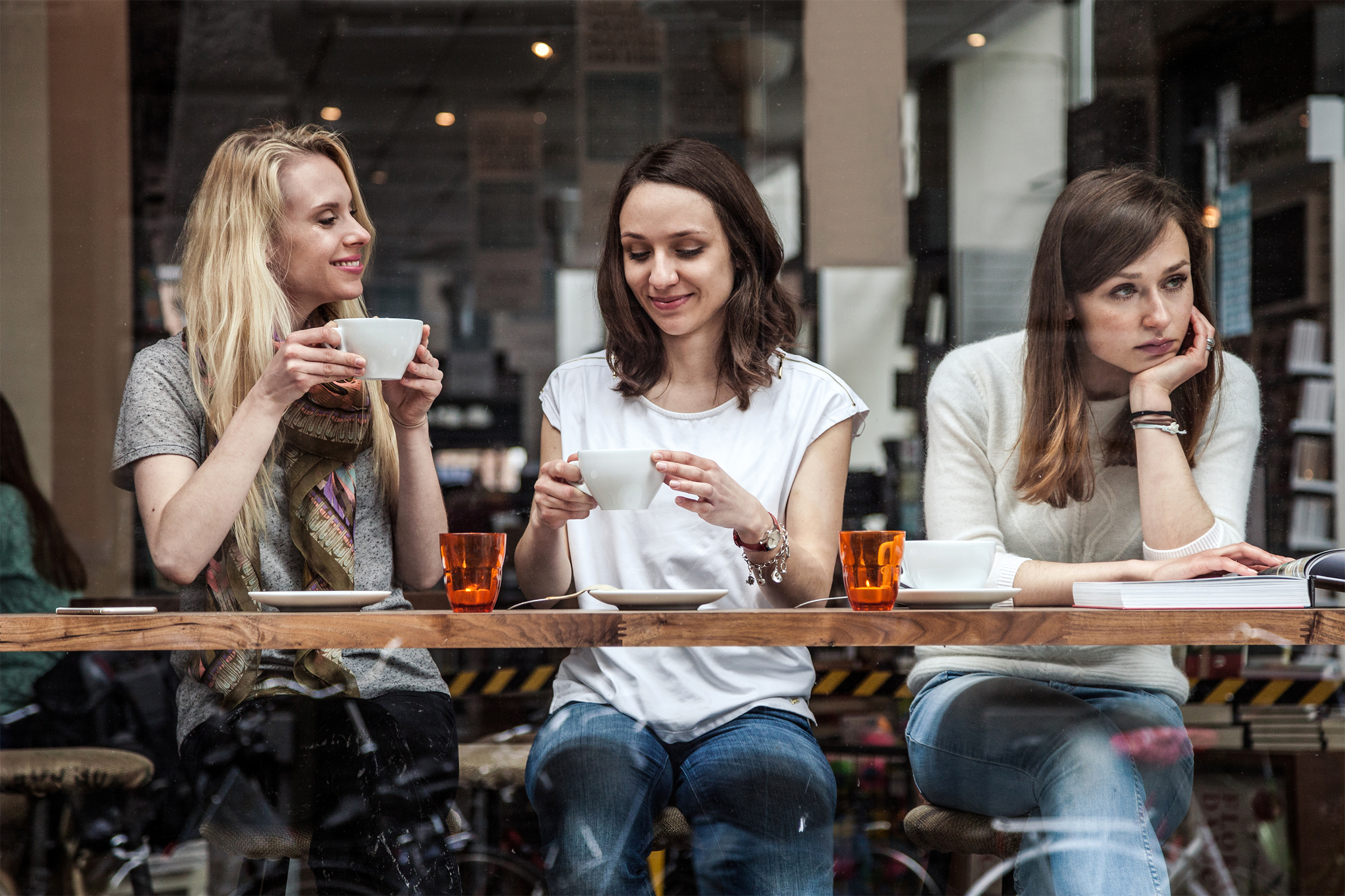 Woman at a cafe ignoring her friends
