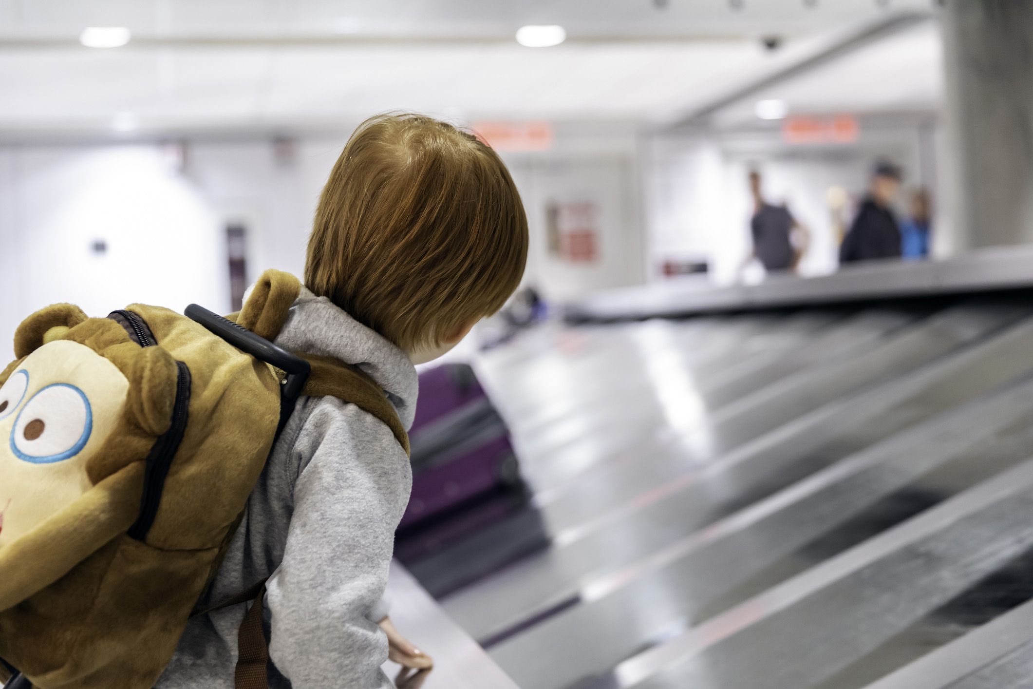 child looking at luggage carousel