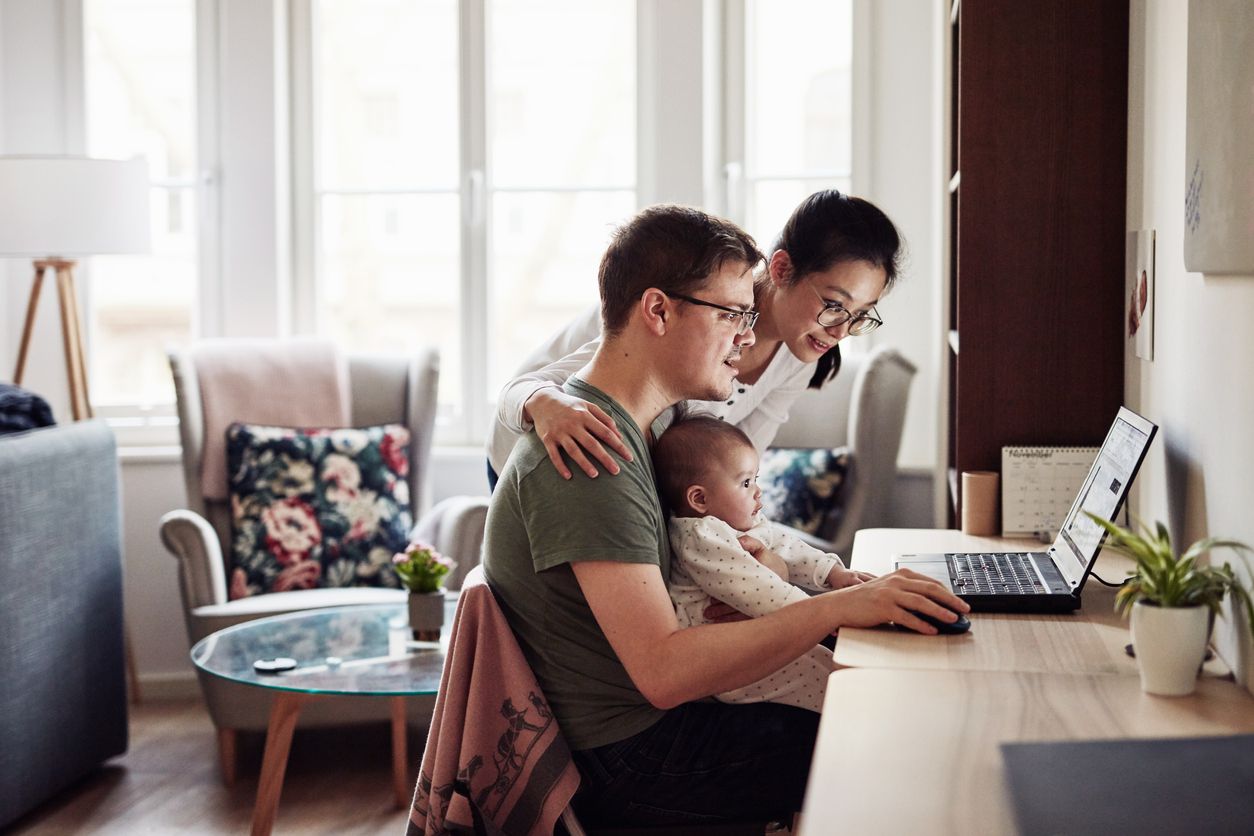Couple with baby looking at computer