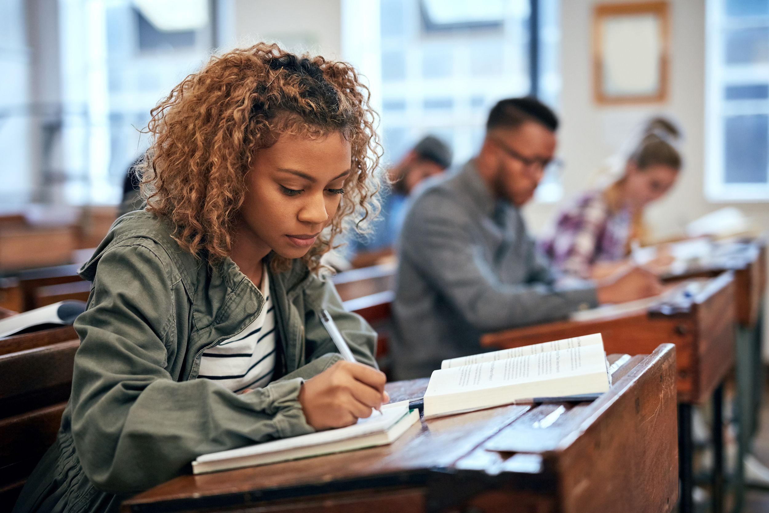 young woman taking notes in a classroom