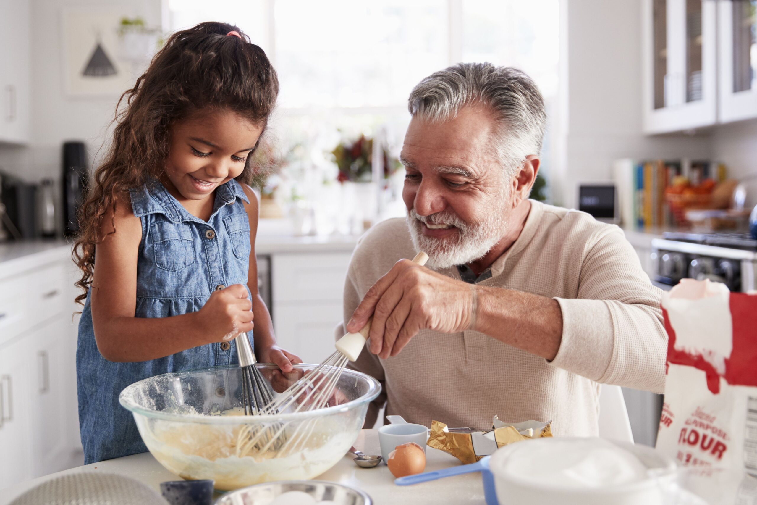 grandfather cooking with his granddaughter