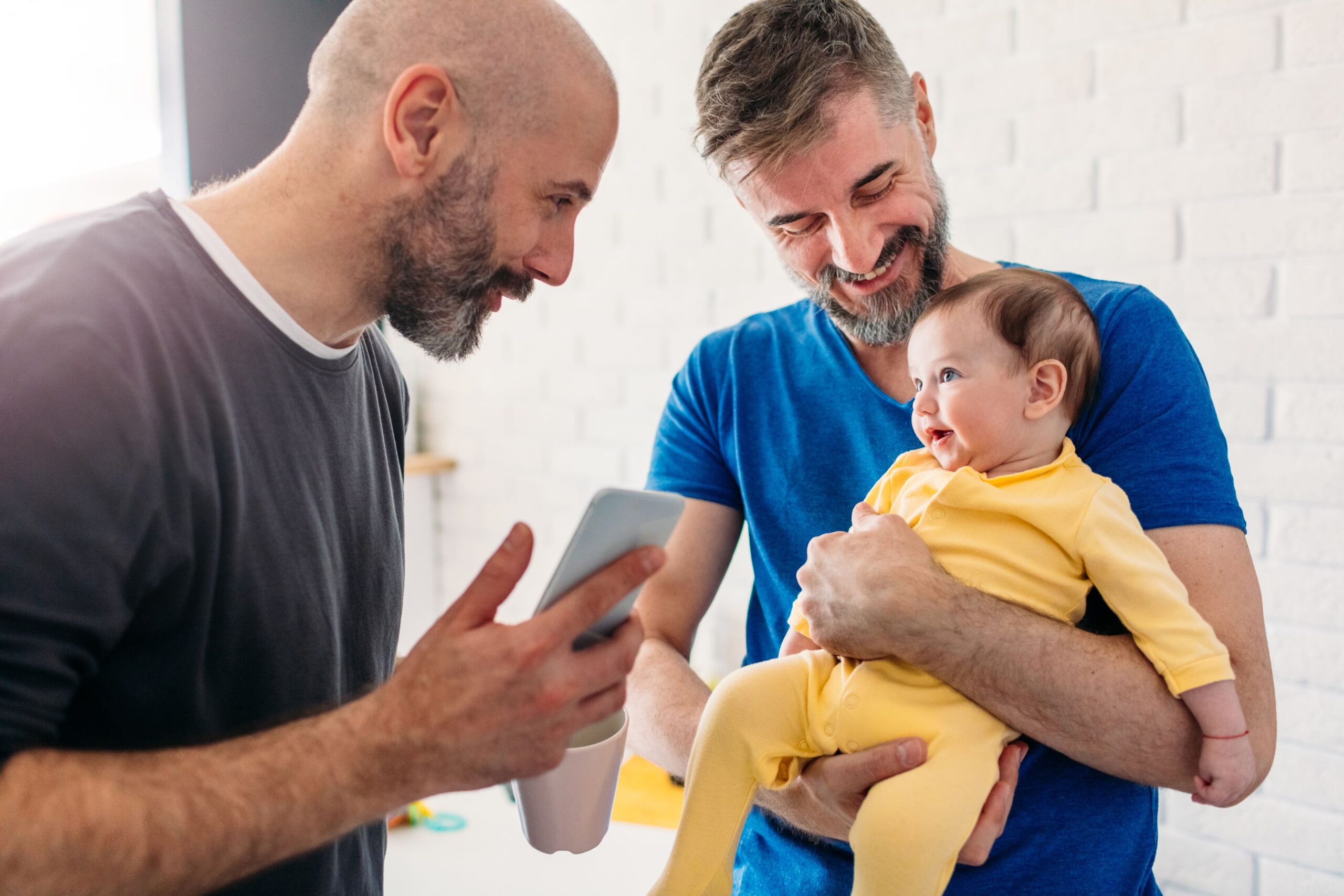 men holding their adopted baby