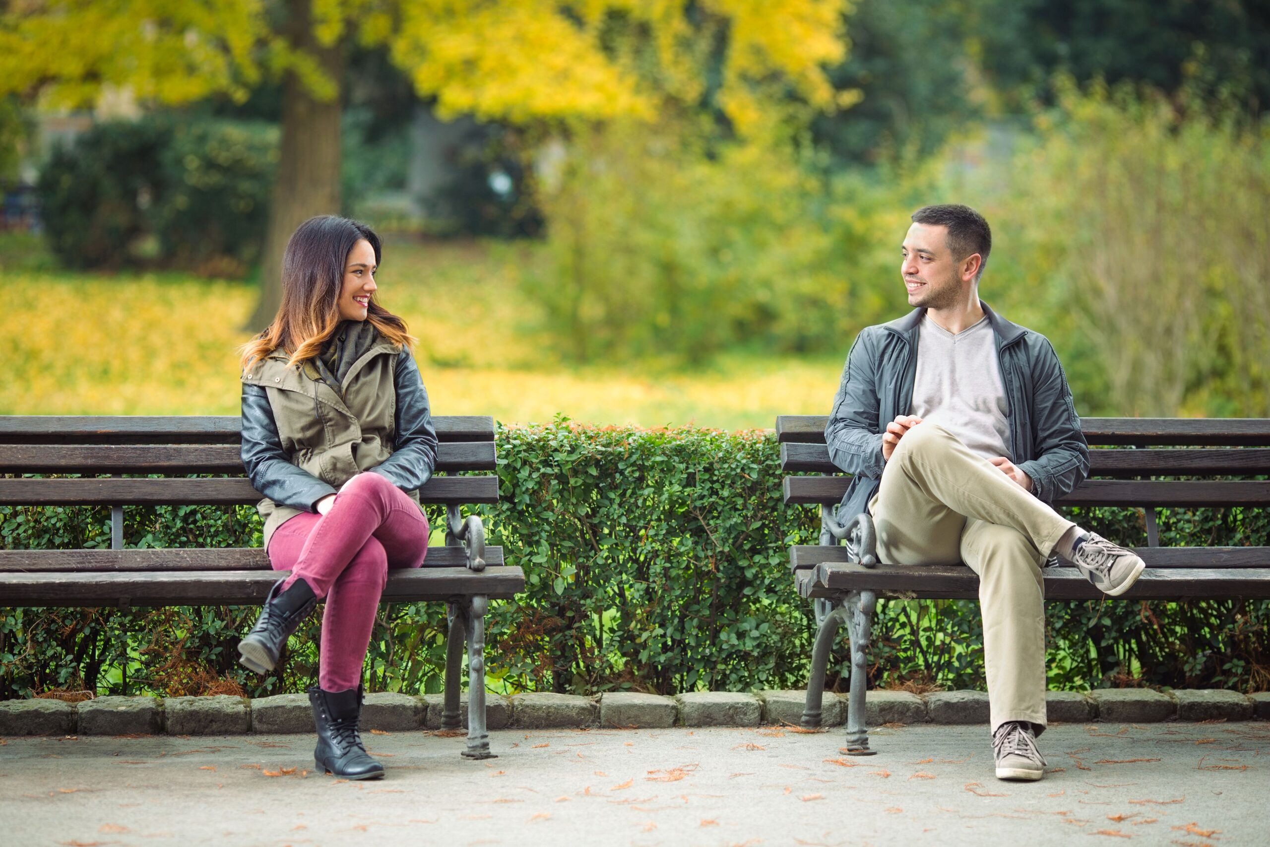 People in love looking at each other on a park bench