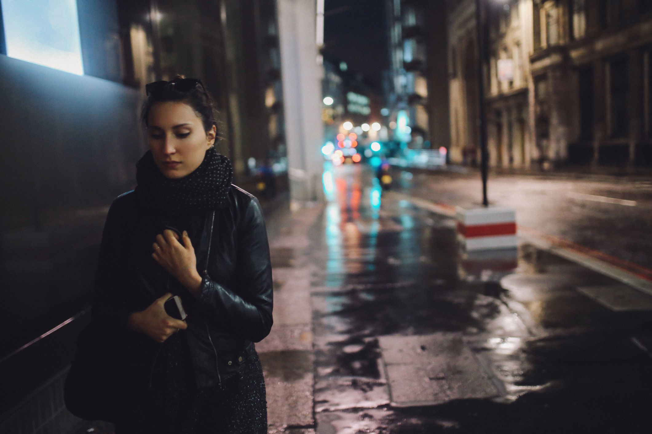 Young woman walking on the streets of London alone, wearing a black leather jacket