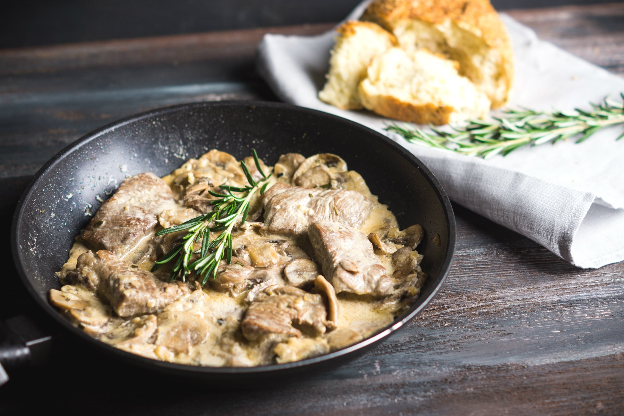 grilled pork and mushrooms with cream sauce on the rustic background
