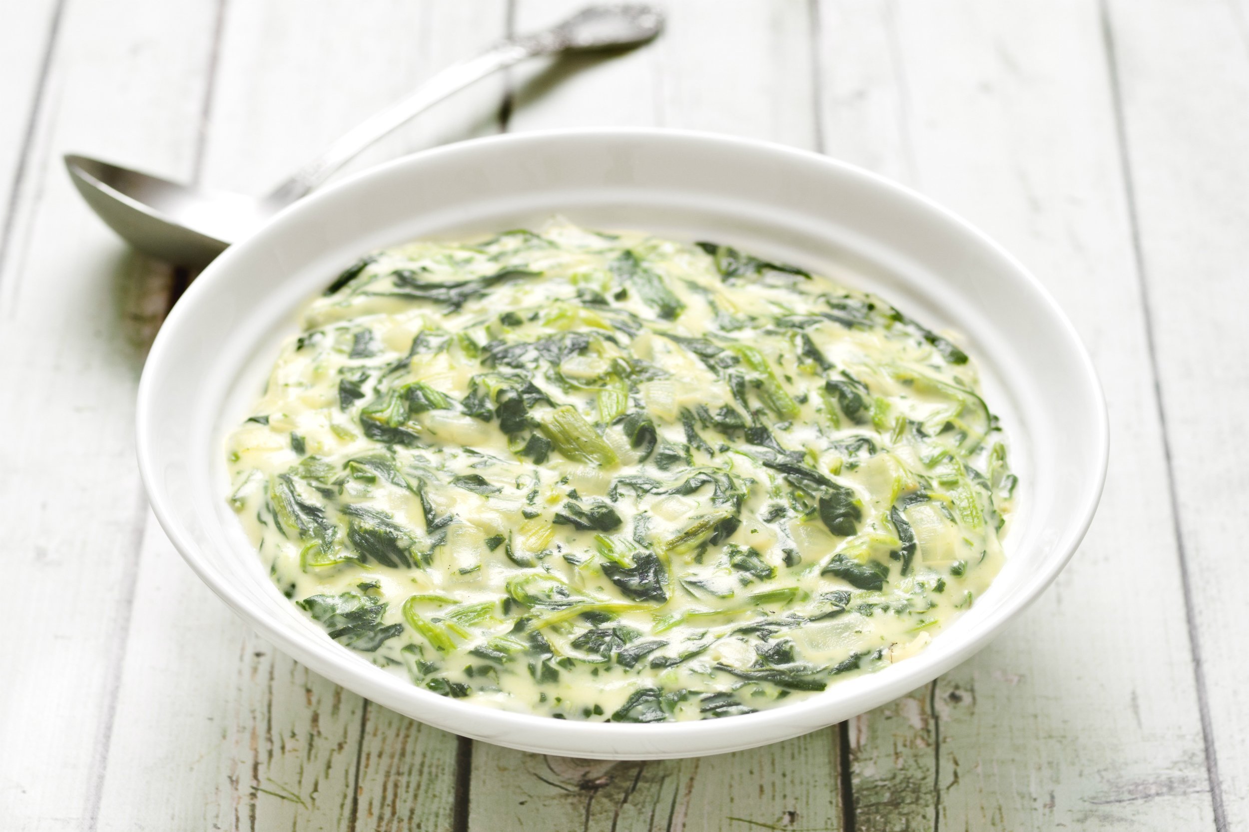 close up of a bowl of rustic creamed spinach