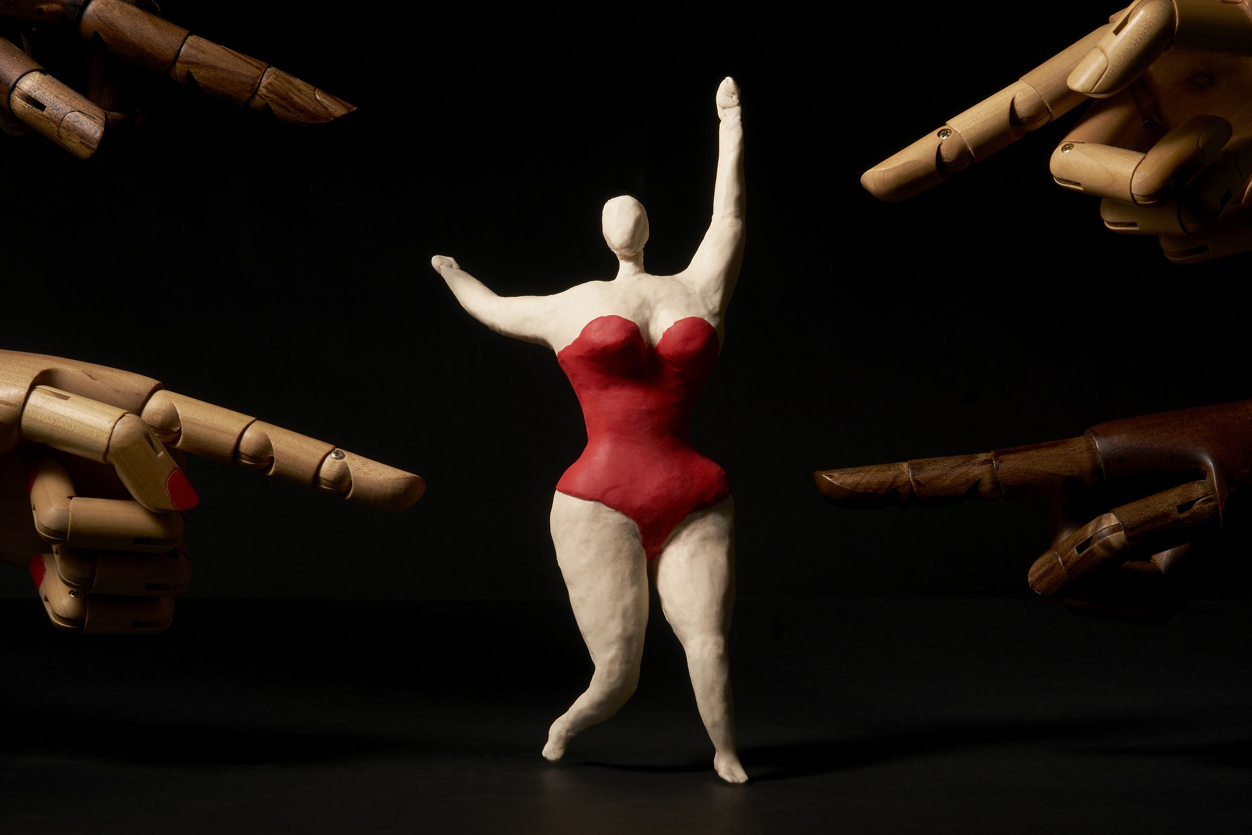 fingers pointing to a happy overweight woman to induce shame