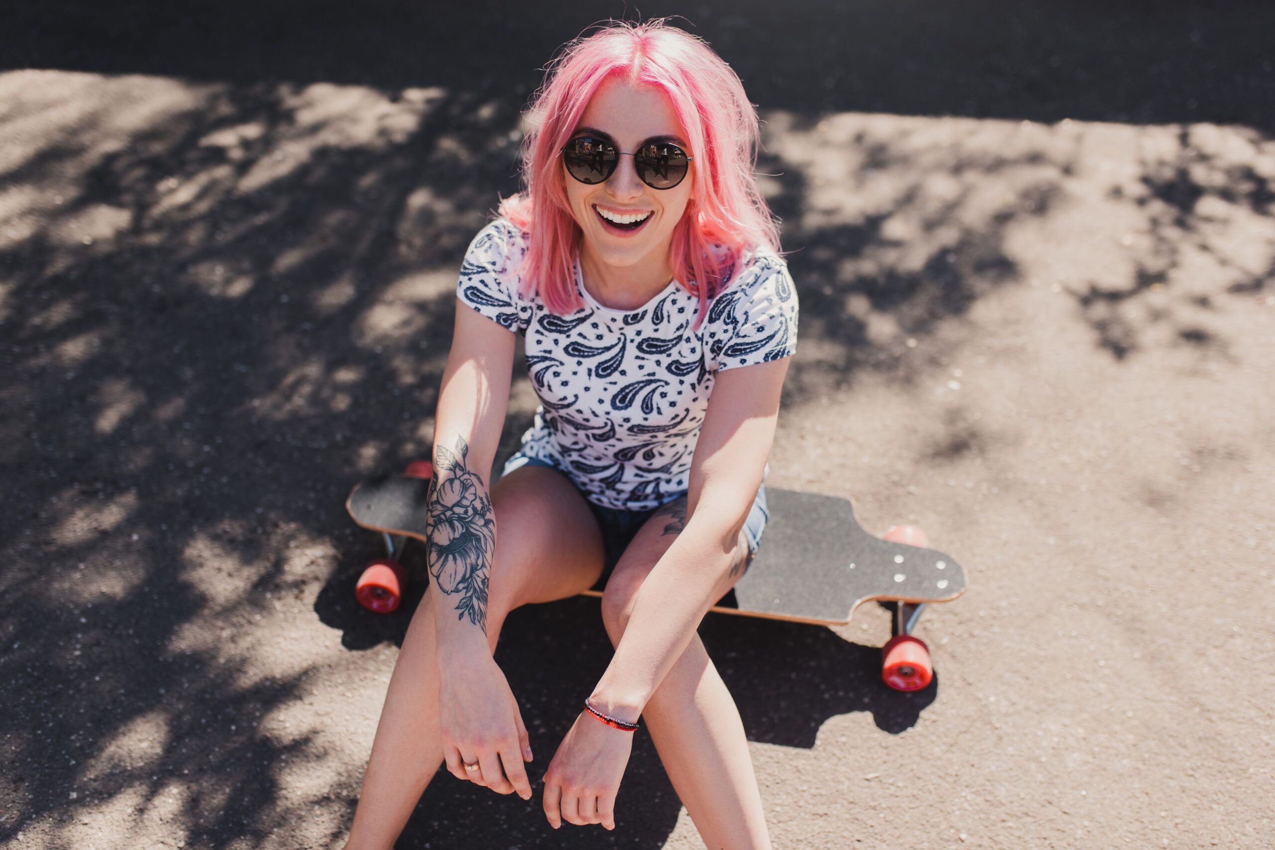 teenager sitting on a skateboard with a tattoo