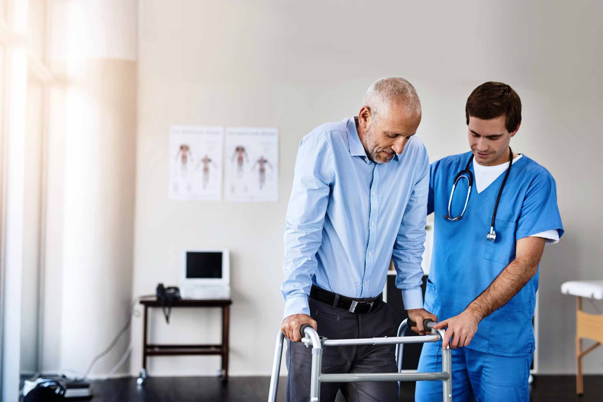 Shot of a male nurse assisting a senior patient with a walker