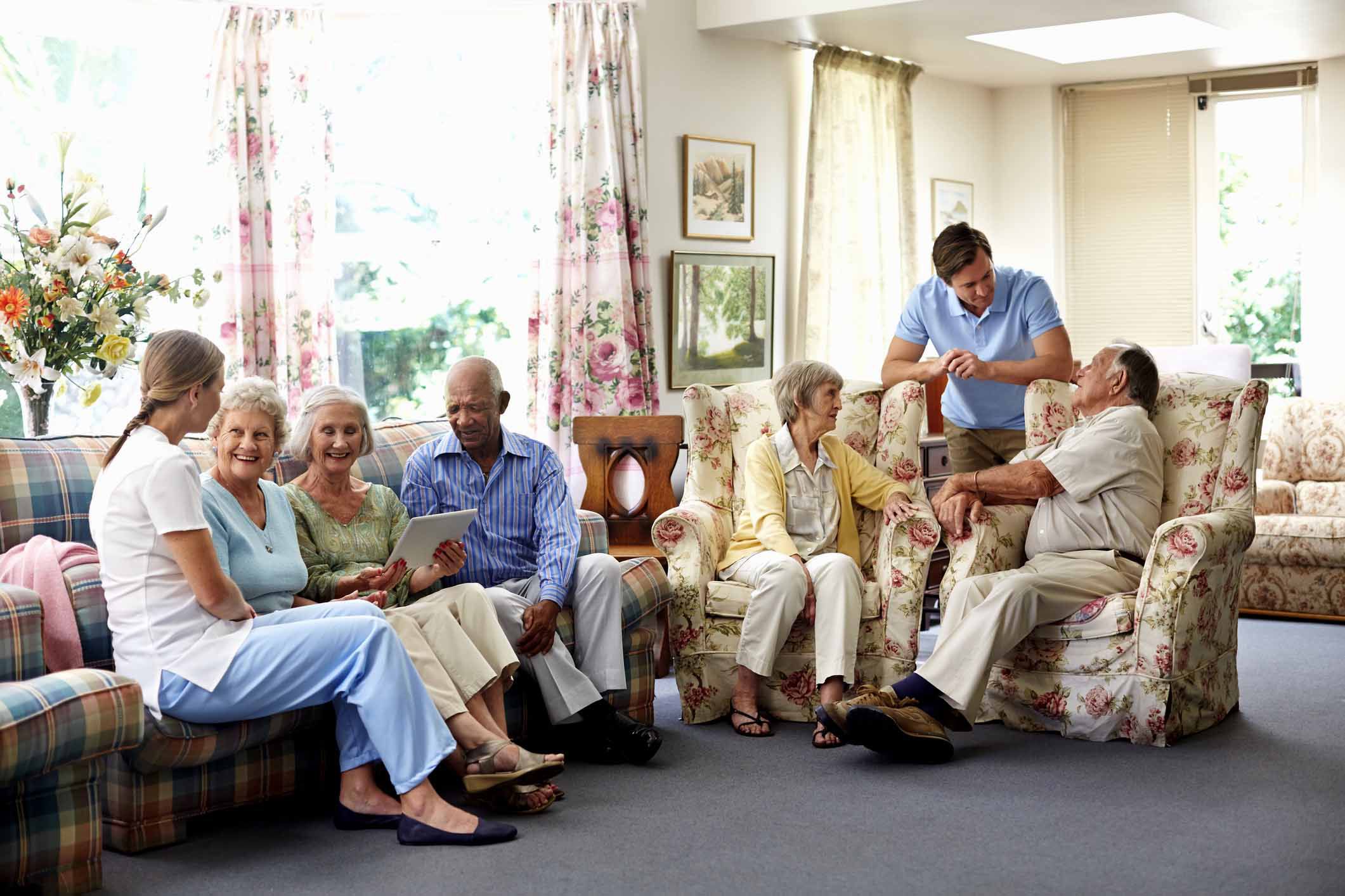 caretakers spending leisure time with retired people in nursing home