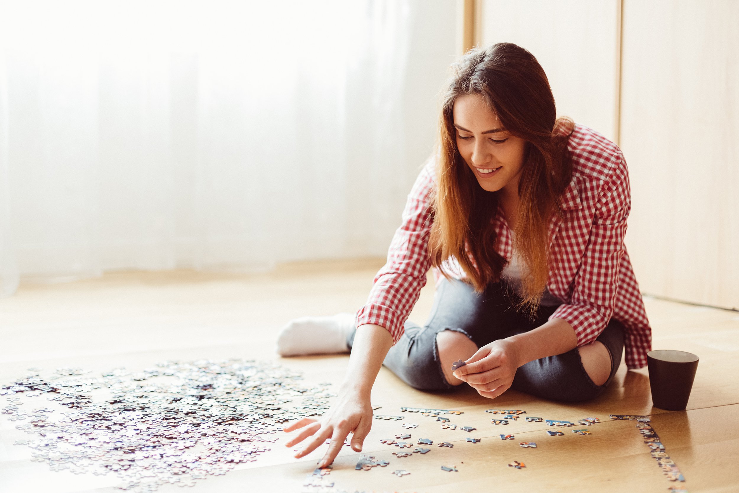 young woman putting puzzle together on floor