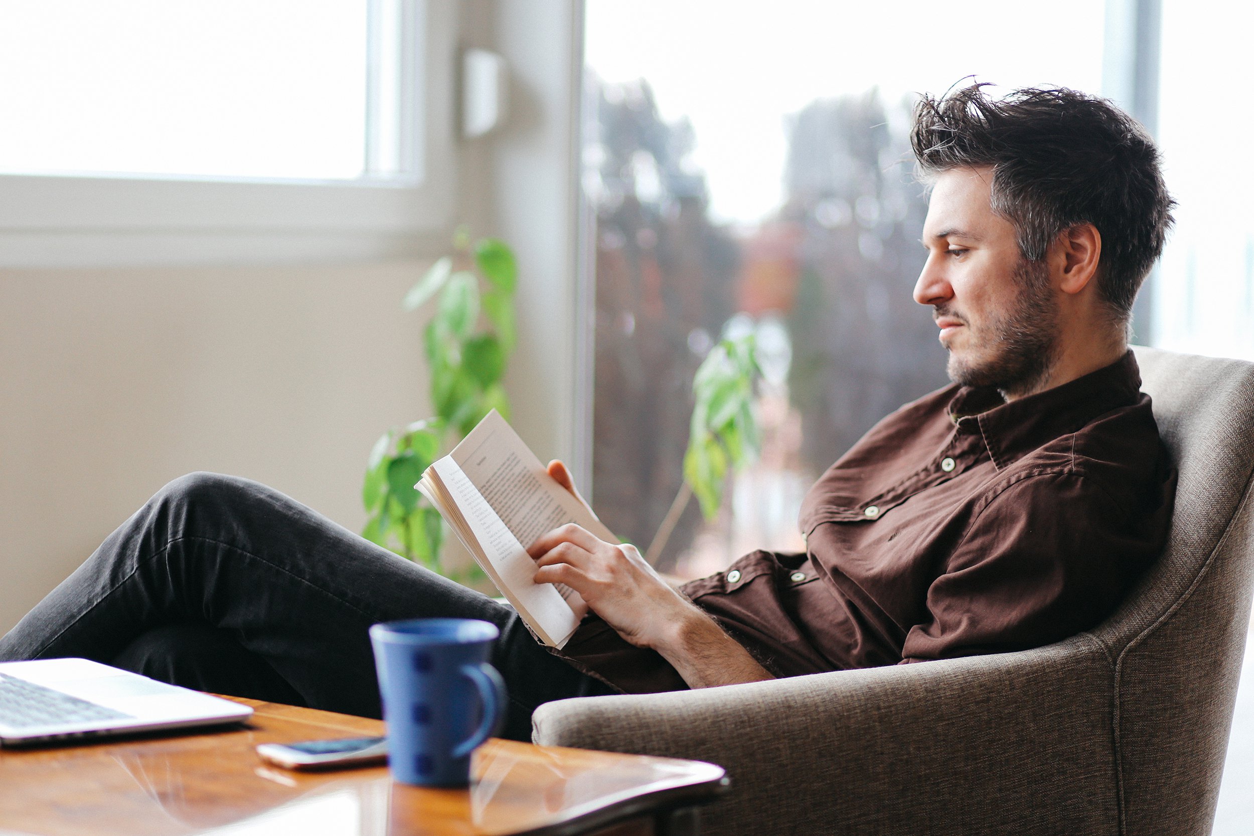 man reading a book at home