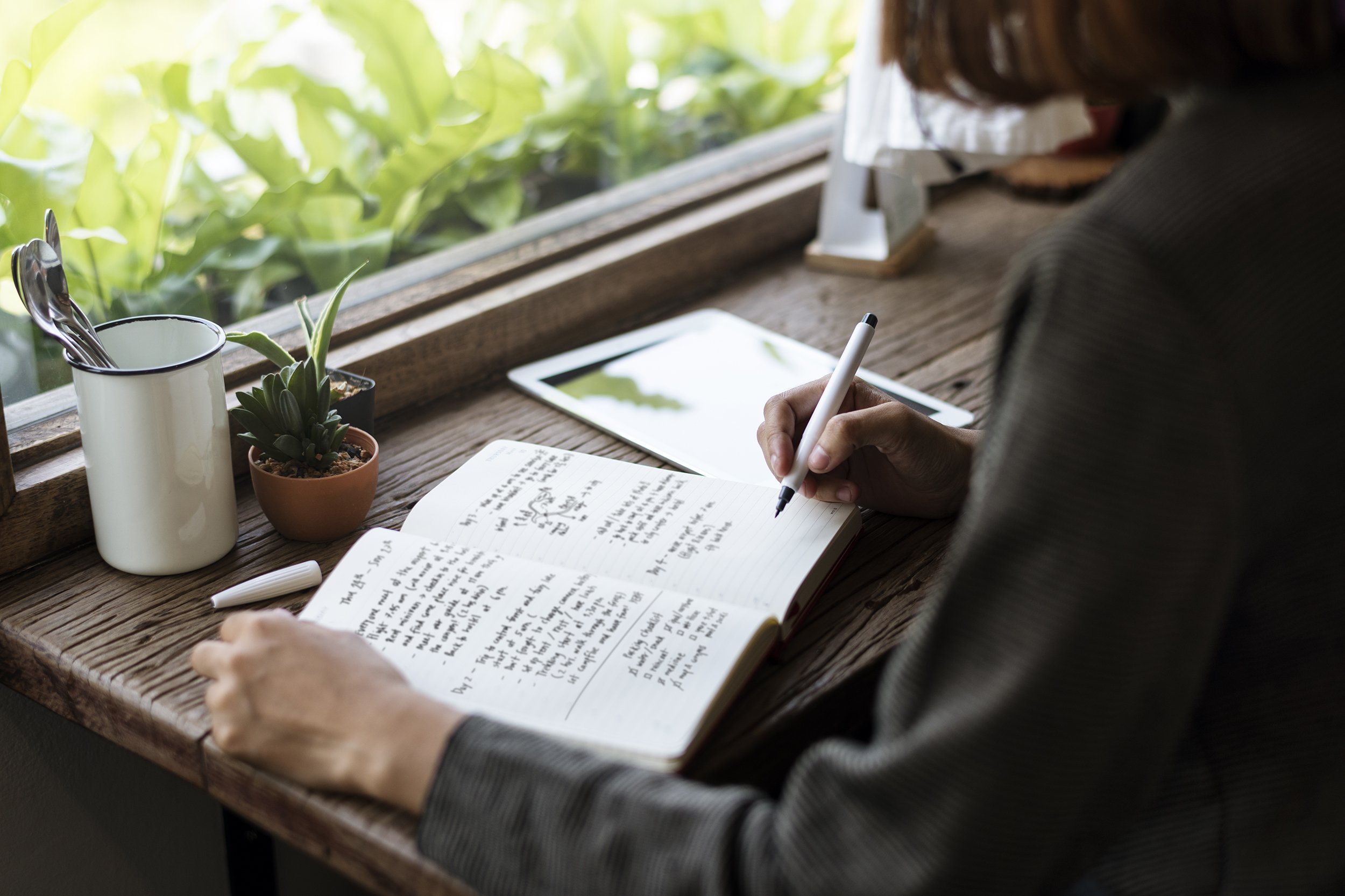 woman at desk writing in journal