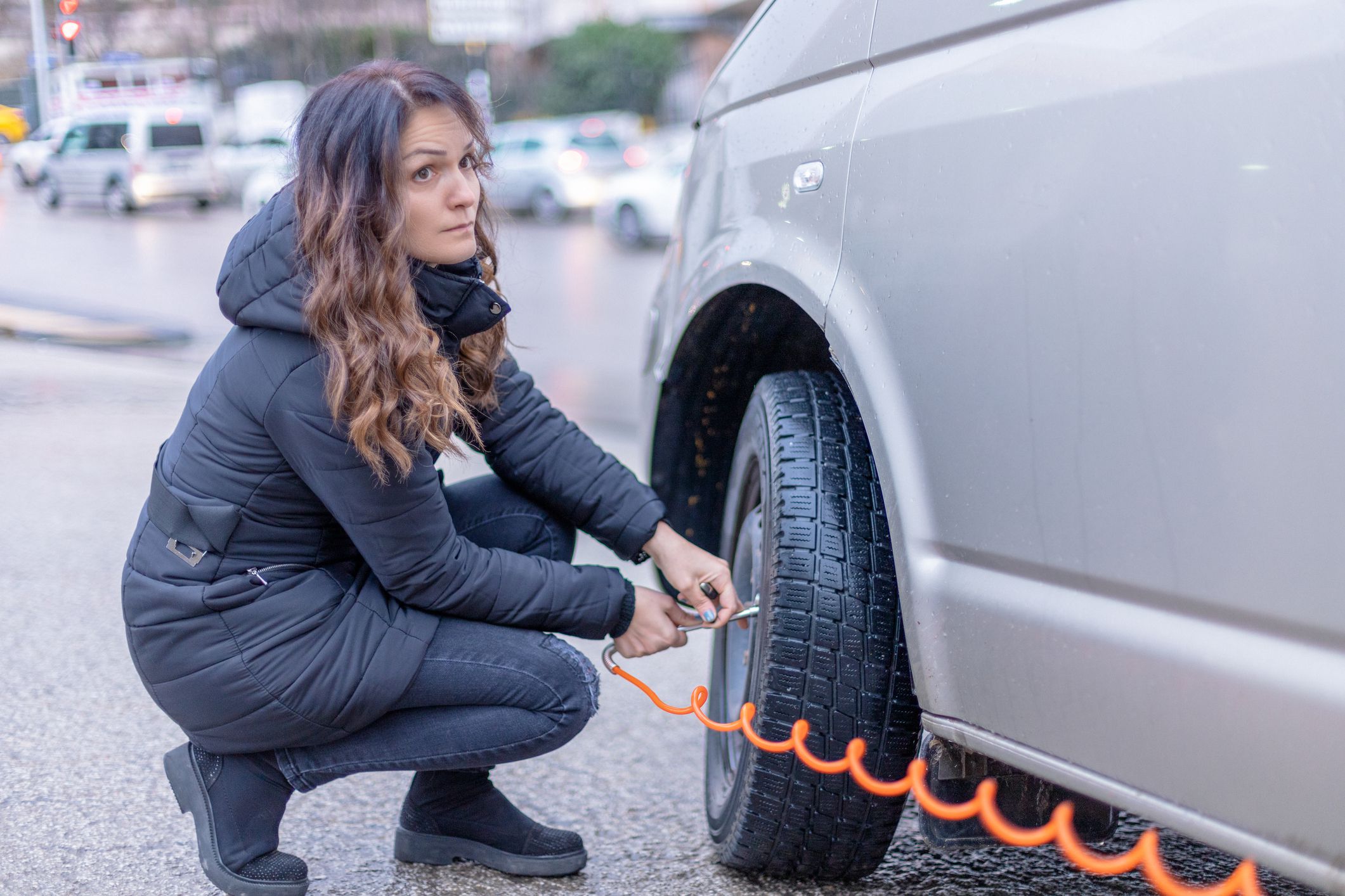 Woman Filling air into a car tire to increase pressure