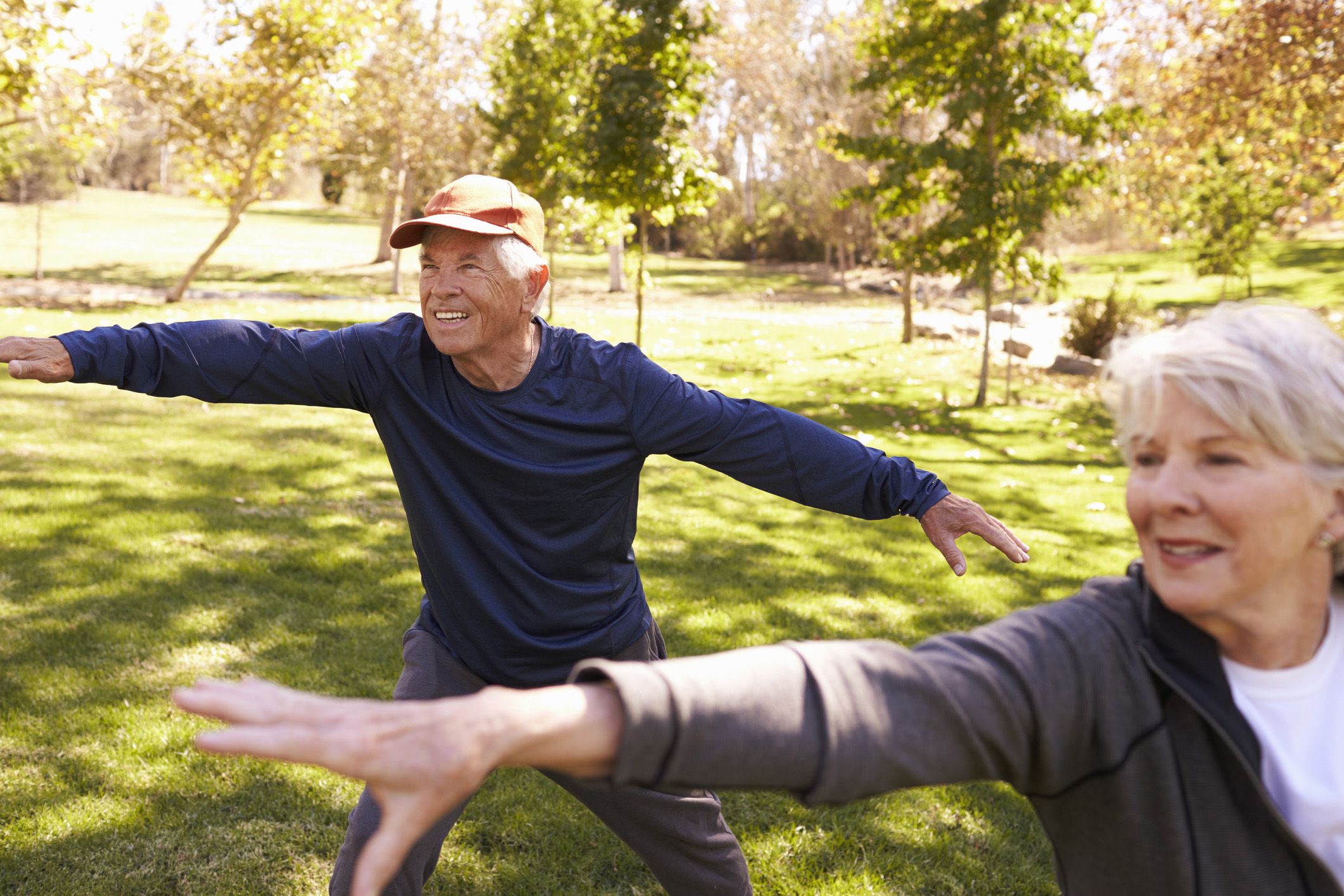 senior couple practicing tai chi in the park